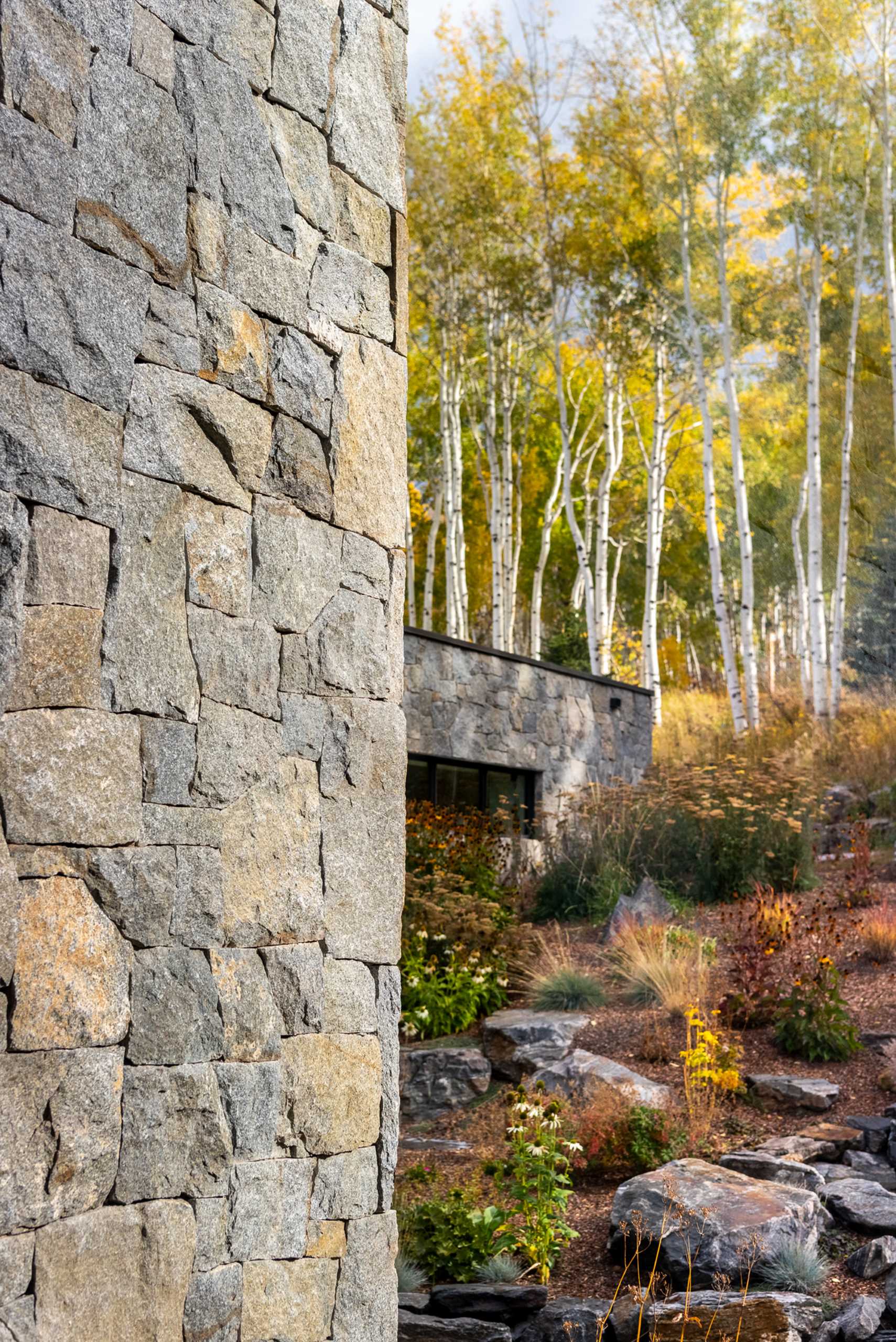 A contemporary mountain home clad in stone, wood, steel, and glass.