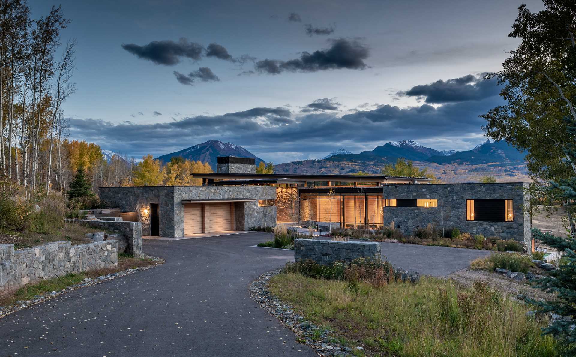 A contemporary mountain home clad in stone, wood, steel, and glass.