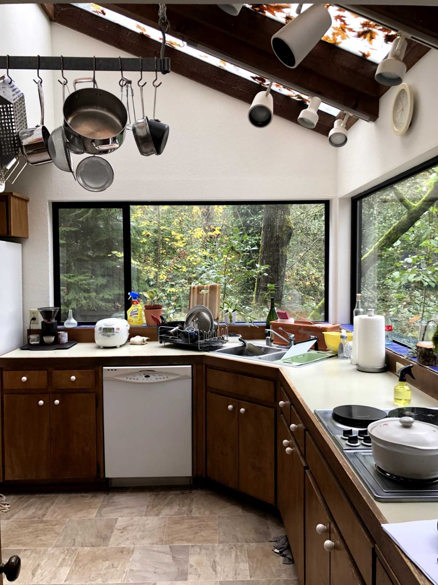 Before photo of a corner kitchen with dark wood cabinets.