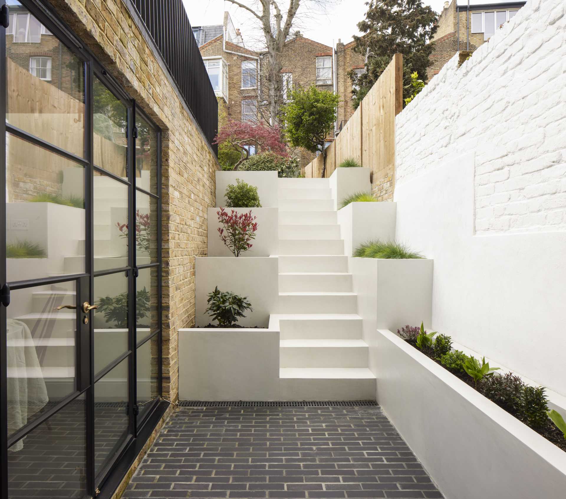 Outdoor stairs with built-in planters leads to a small patio and breakfast room.
