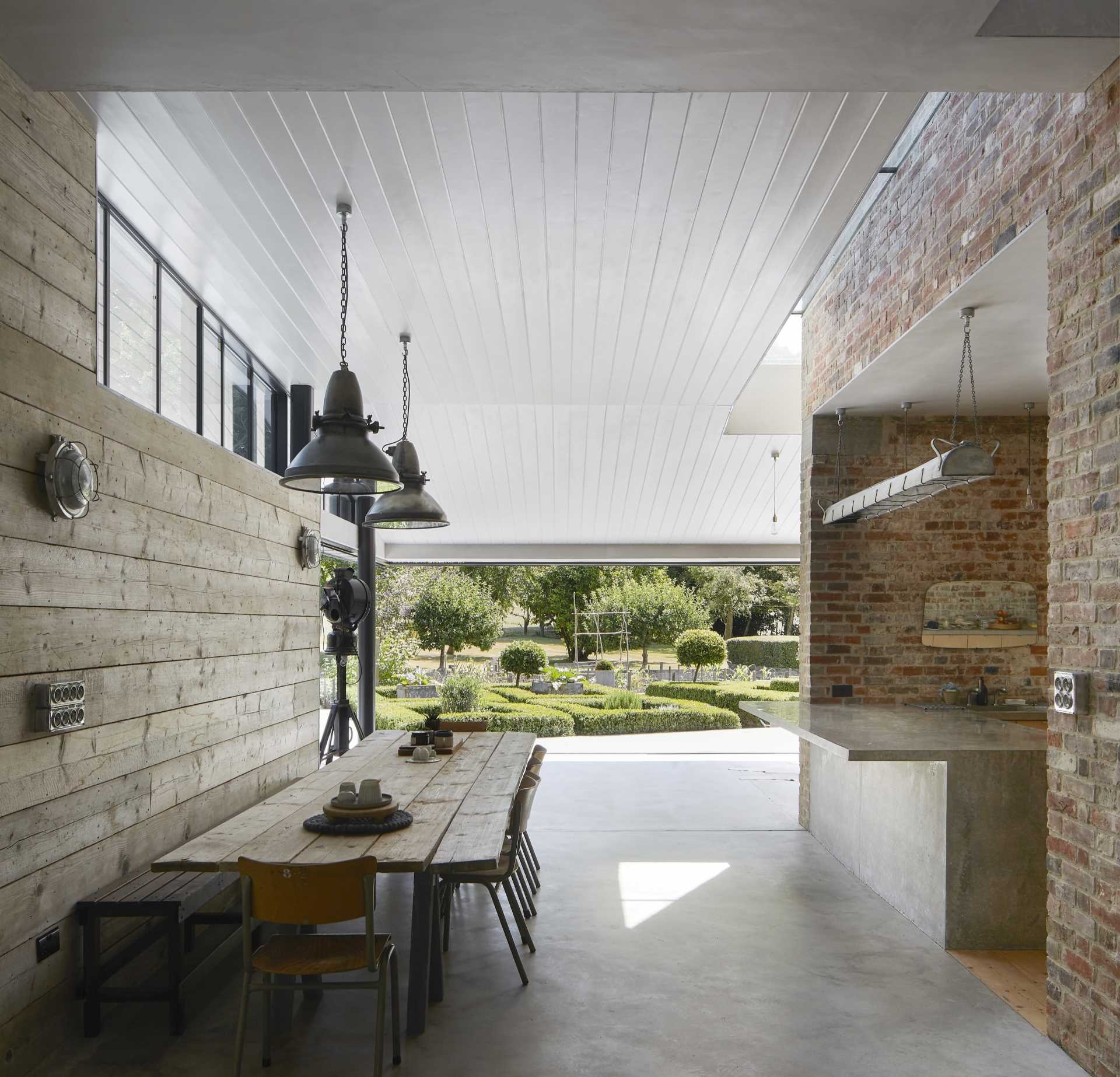 A new home addition makes room for a dining table, while the new kitchen exists within the brick walls of the original home.