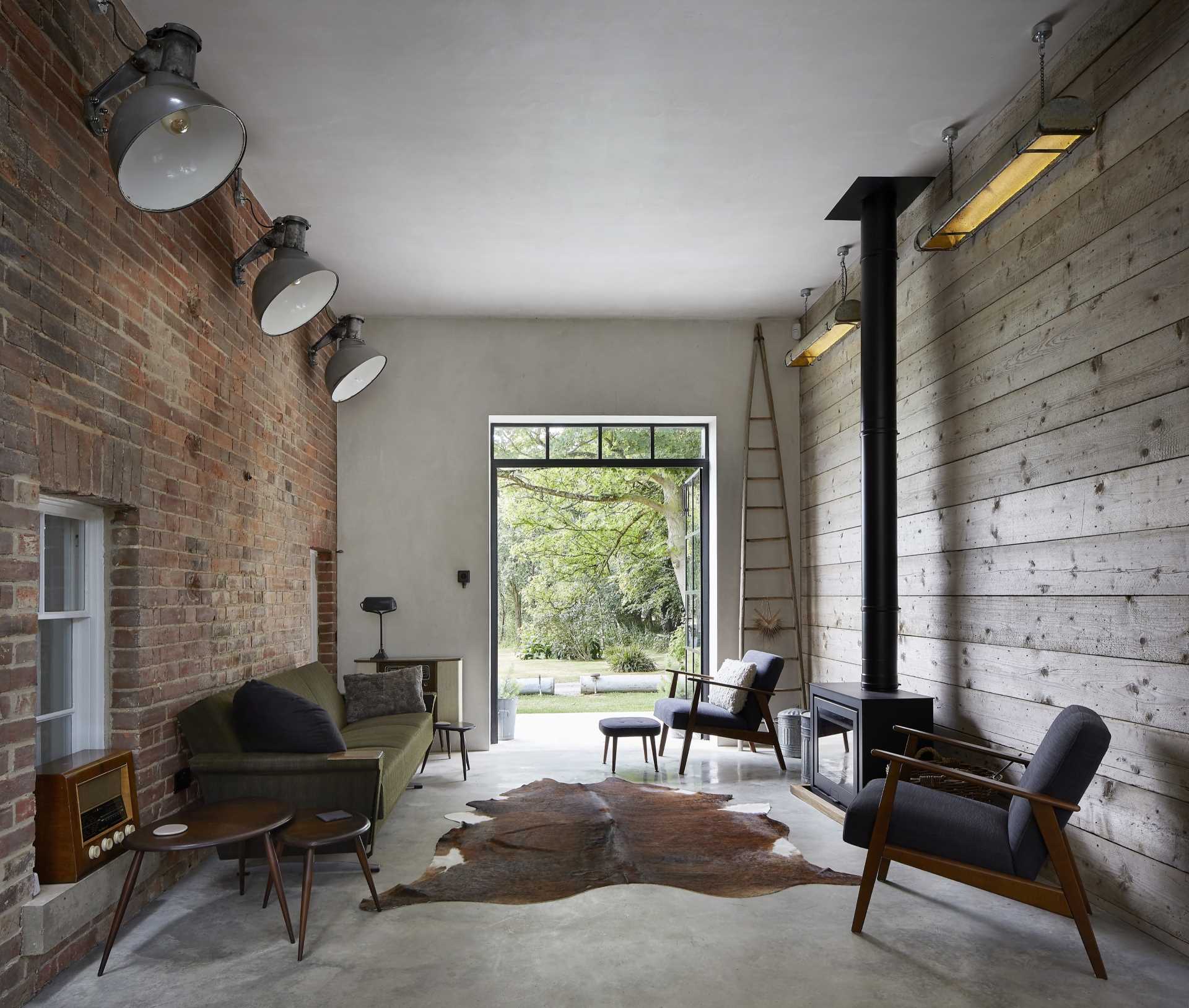A home addition with a living room that includes the original brick wall and windows as an accent wall.