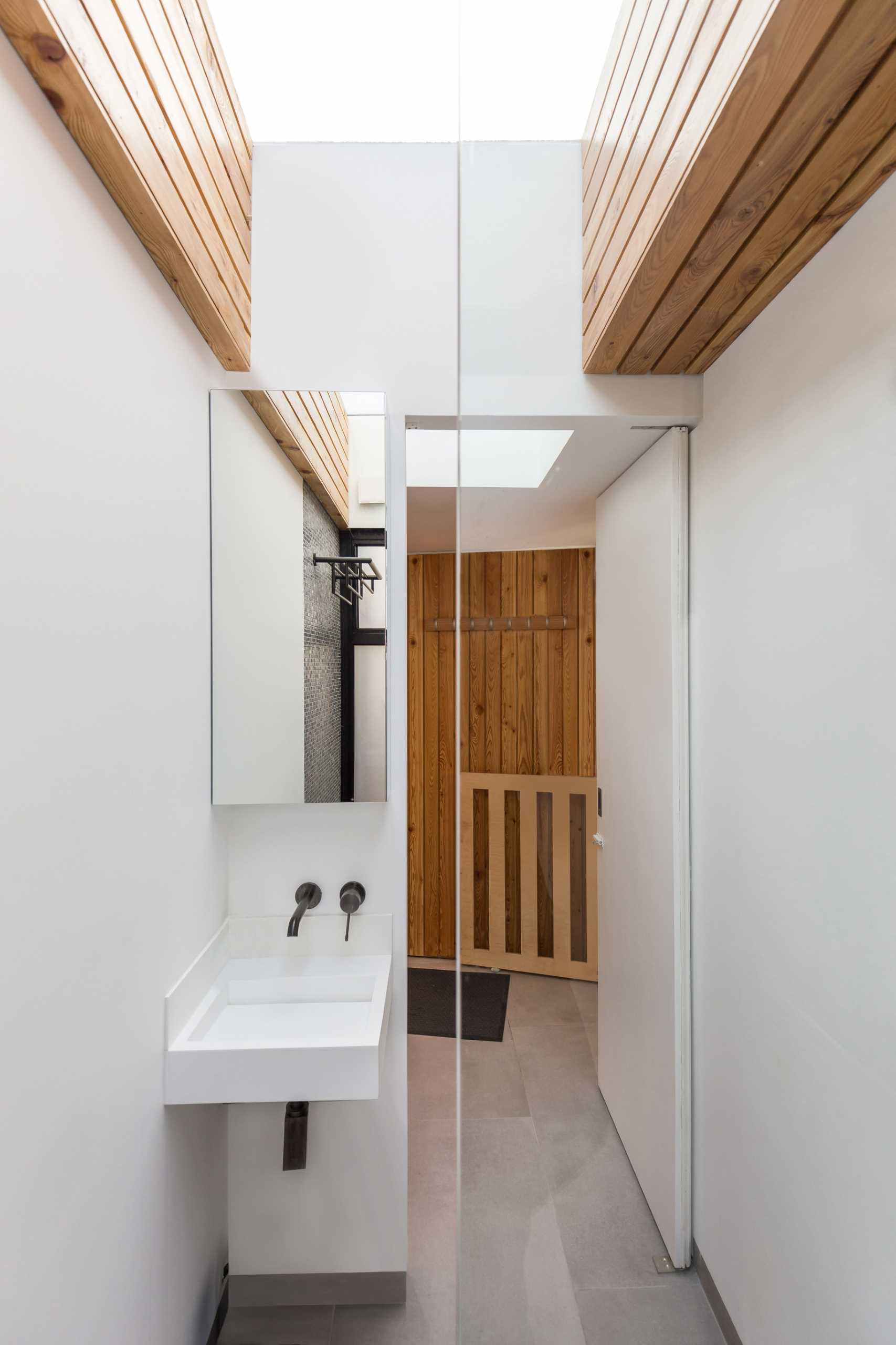 A small bathroom with a shower and a skylight.