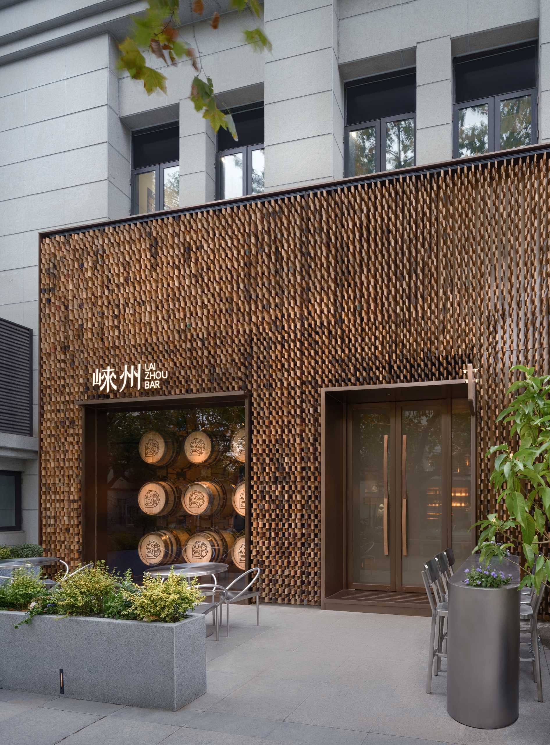 6000 pieces of discarded wooden whiskey barrels were recycled to make the facade of this modern bar.
