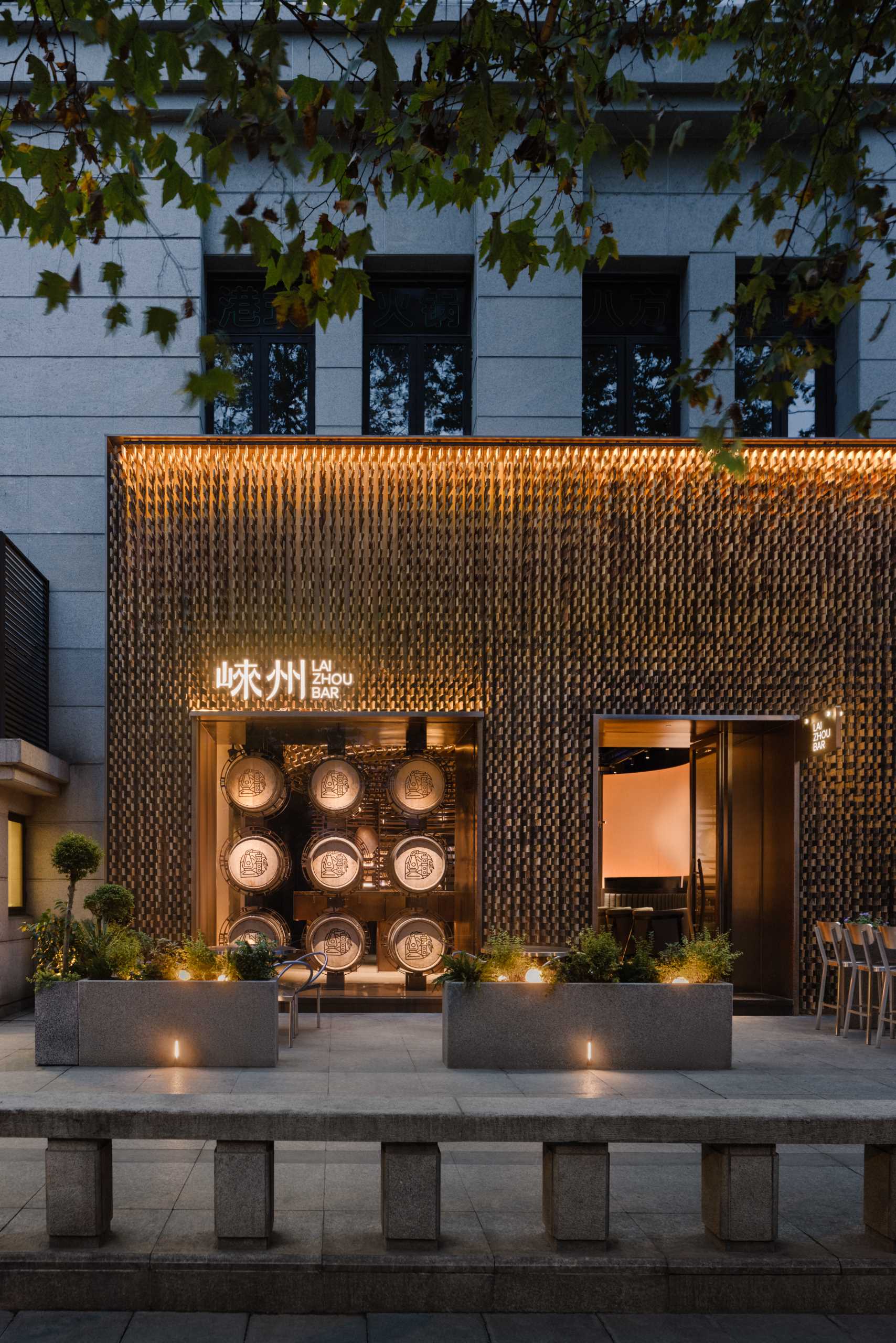 6000 pieces of discarded wooden whiskey barrels were recycled to make the facade of this modern bar.