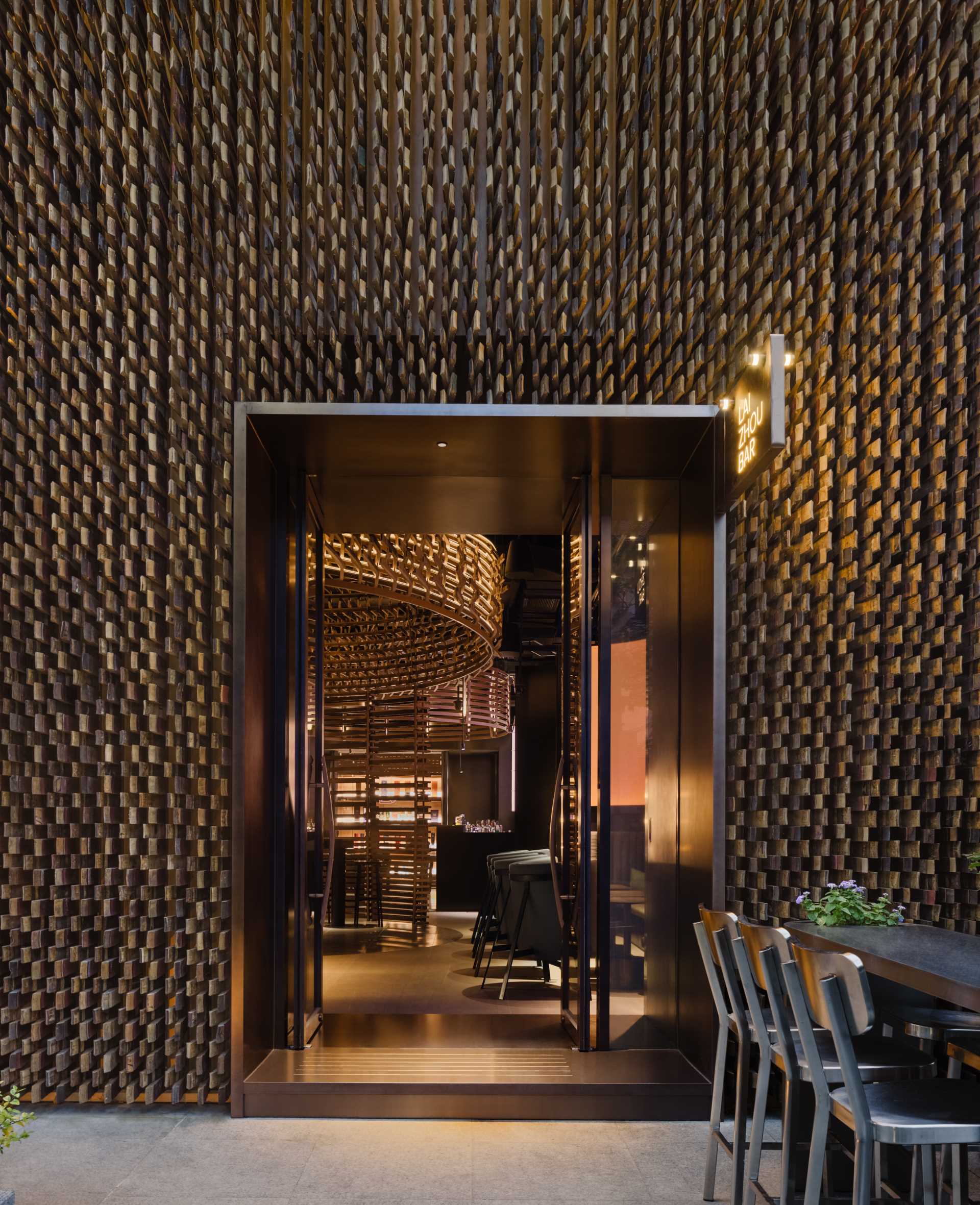 6000 pieces of discarded wooden whiskey barrels were recycled to make the facade and interior of this modern bar.