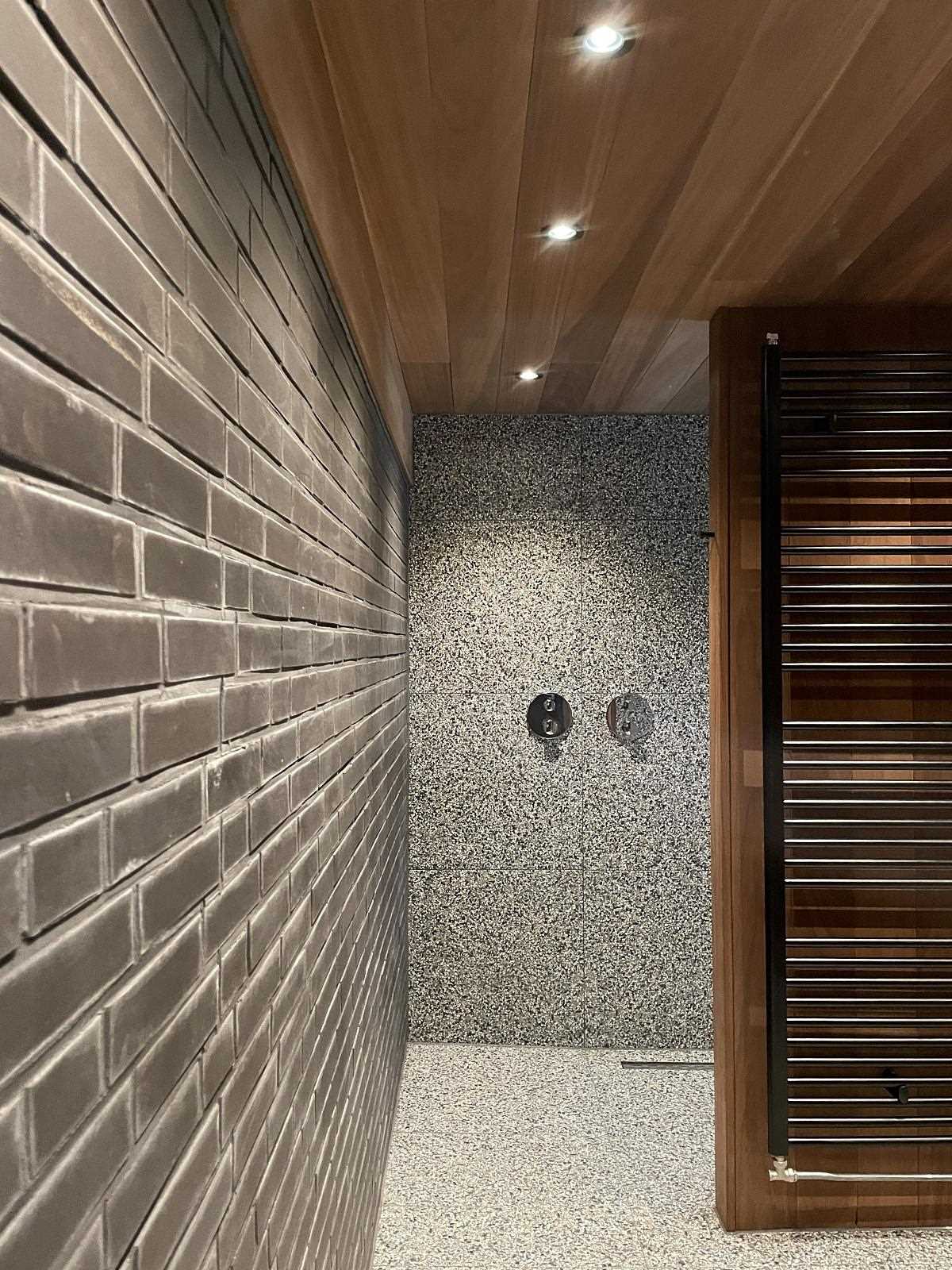 A modern bathroom with a black brick wall.