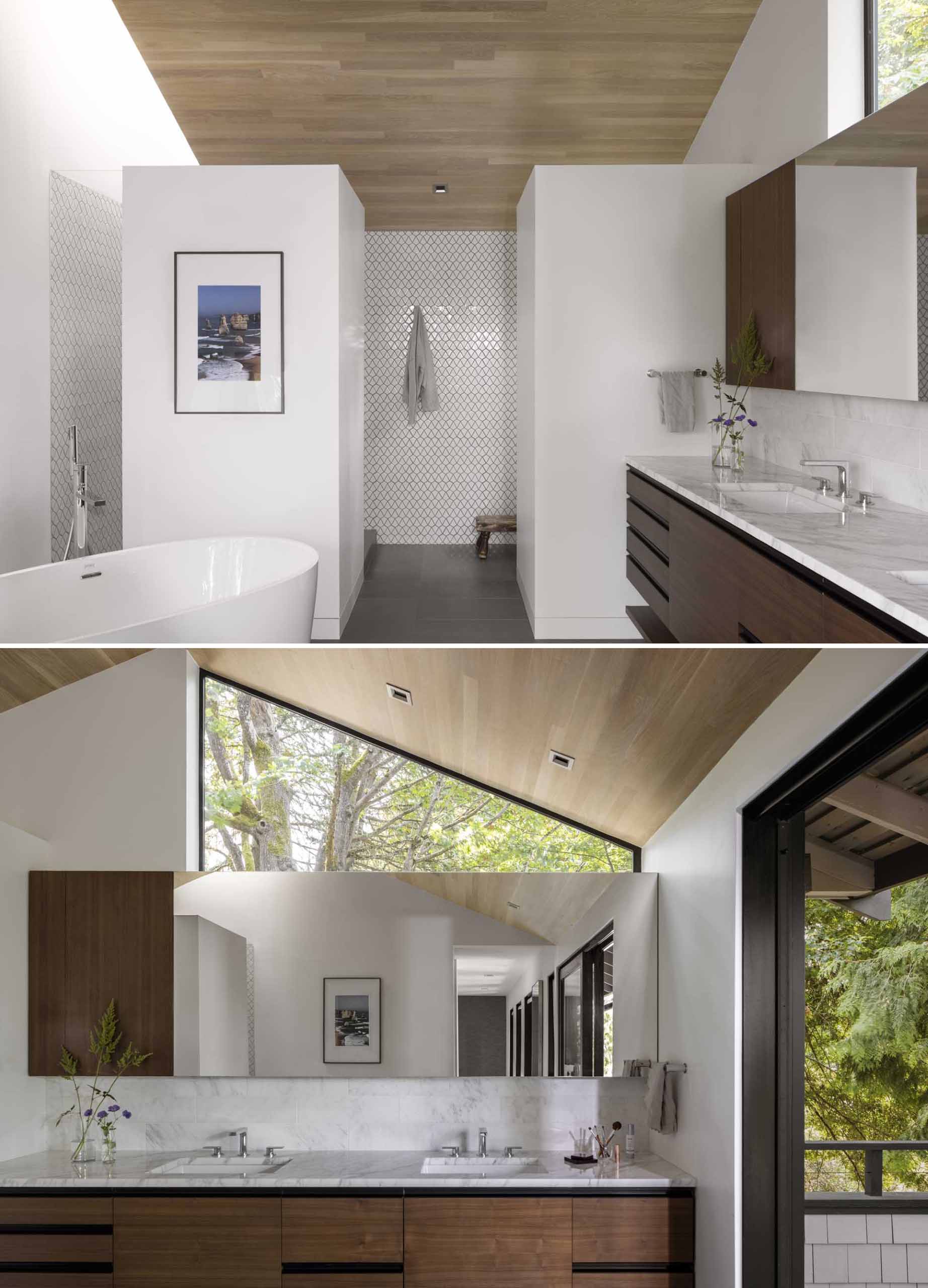 A remodeled bathroom has free-standing tub and south-facing vanity for two that are separated by a pair of part-height walls that allow light to spill over into a private walk-in shower area that is topped by a skylight and toilet room.