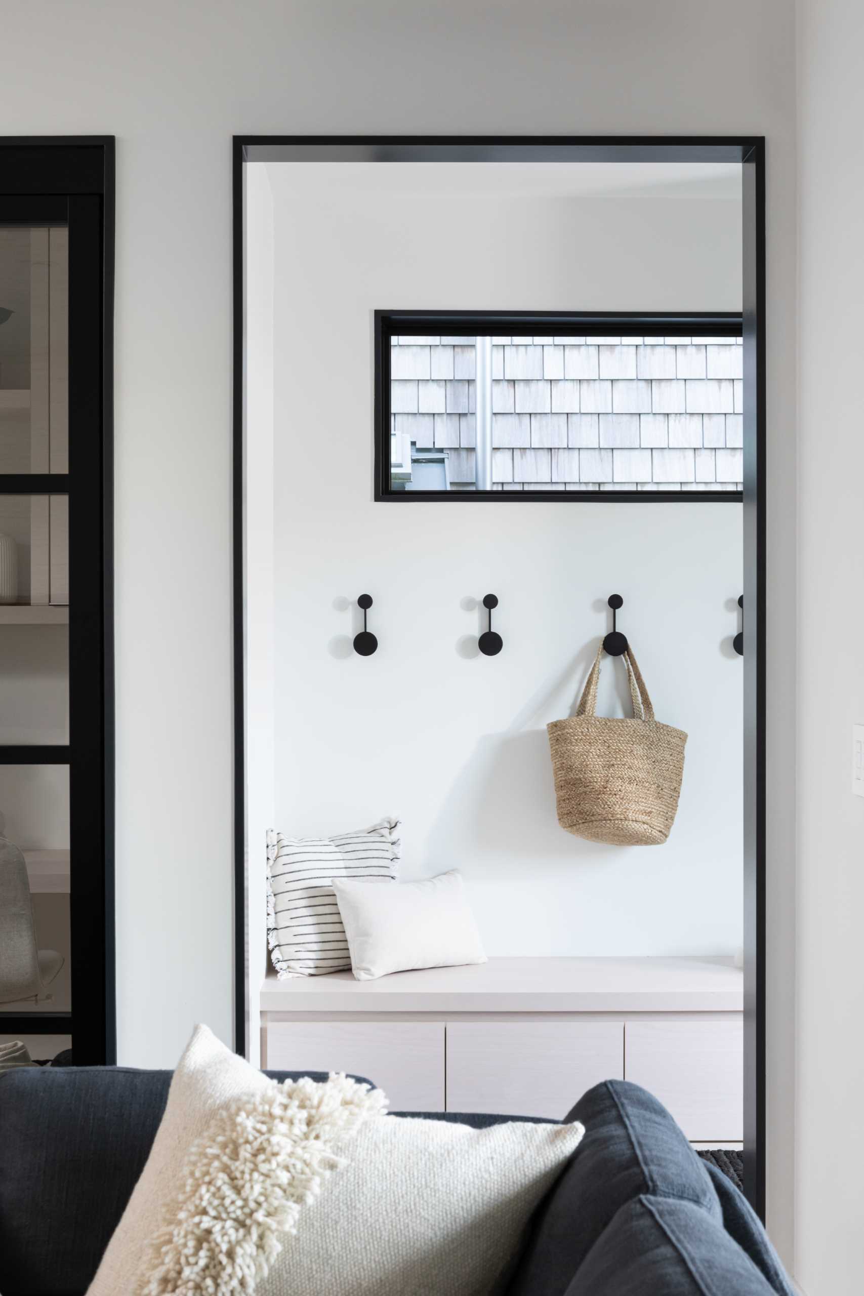 Inside this modern home, there's black openings and window frames that contrast the white walls.