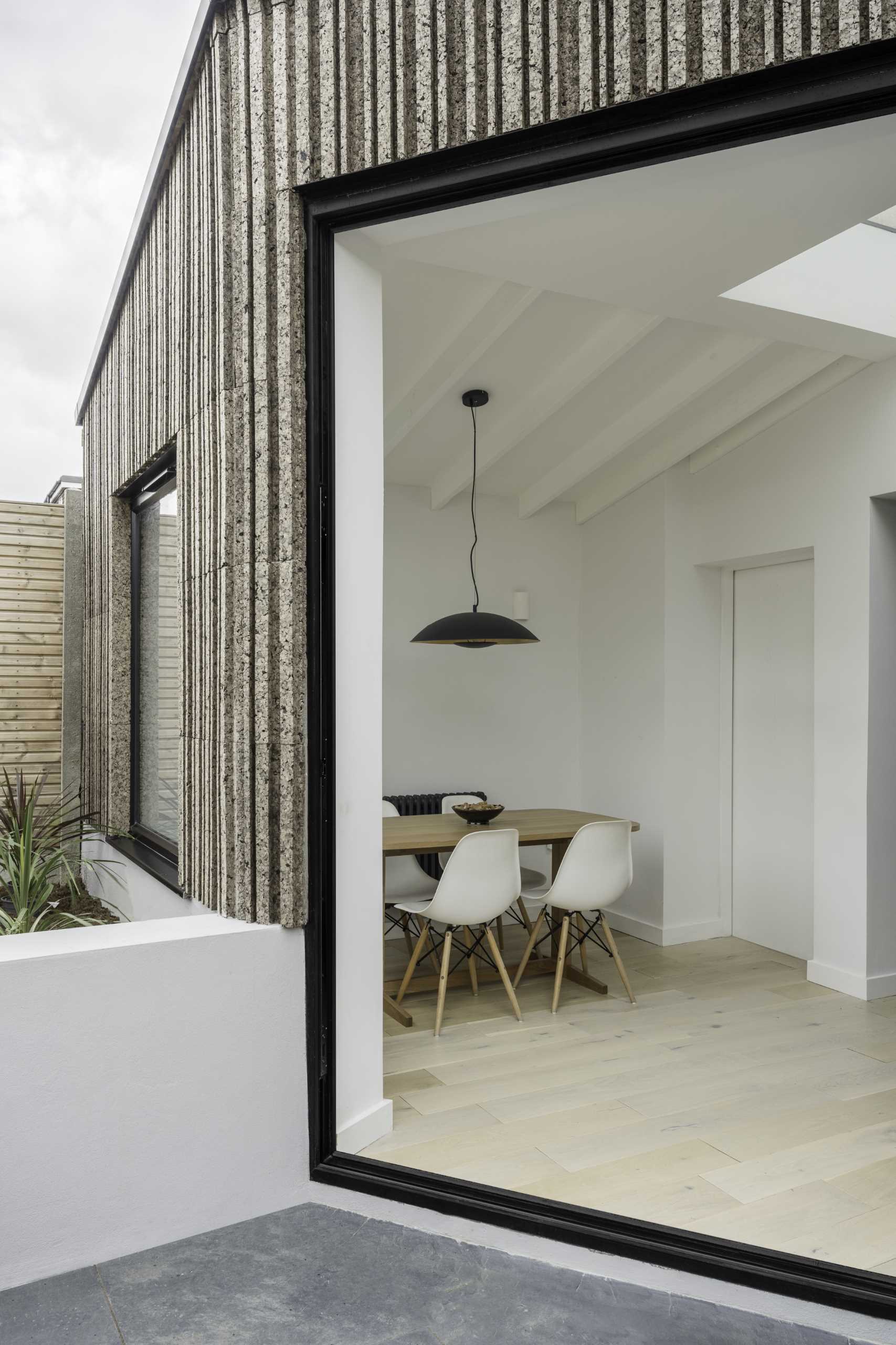 A modern home extension that's clad in patterned cork, includes new space for a dining area and kitchen.