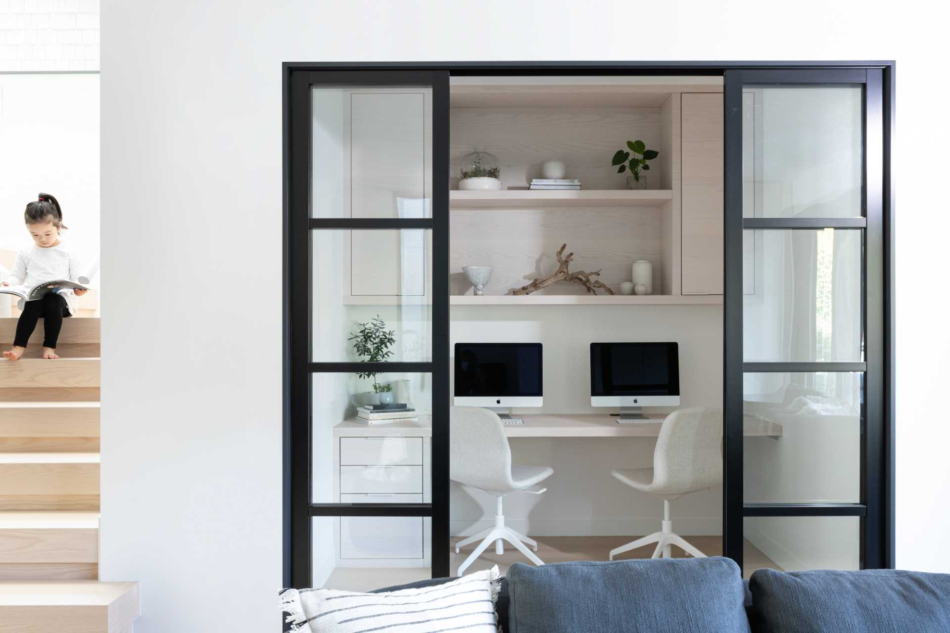 A small home office for two with wood shelving, cabinets, and a desk with drawers.
