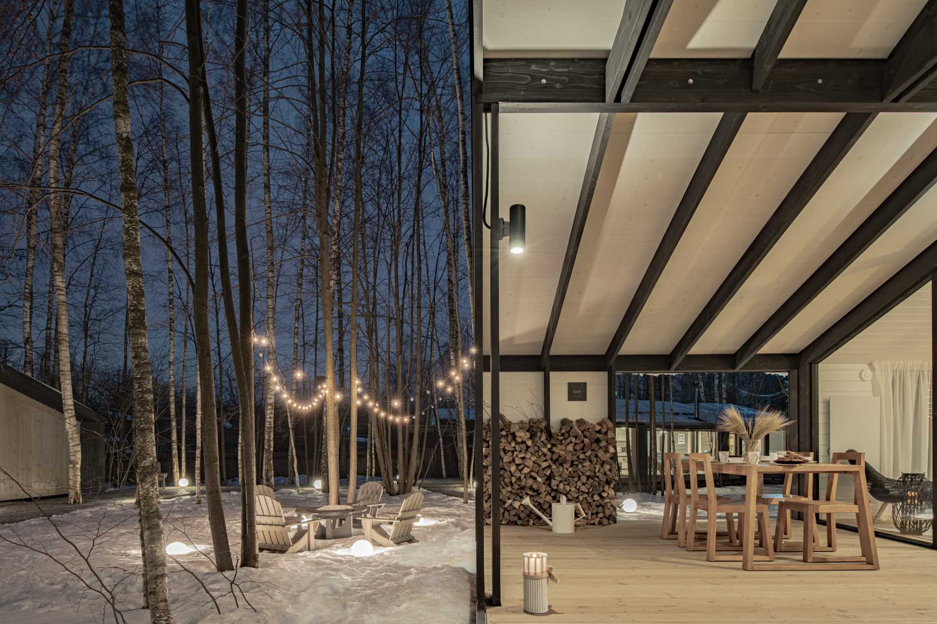 A modular home with a covered outdoor space for entertaining and storing wood.