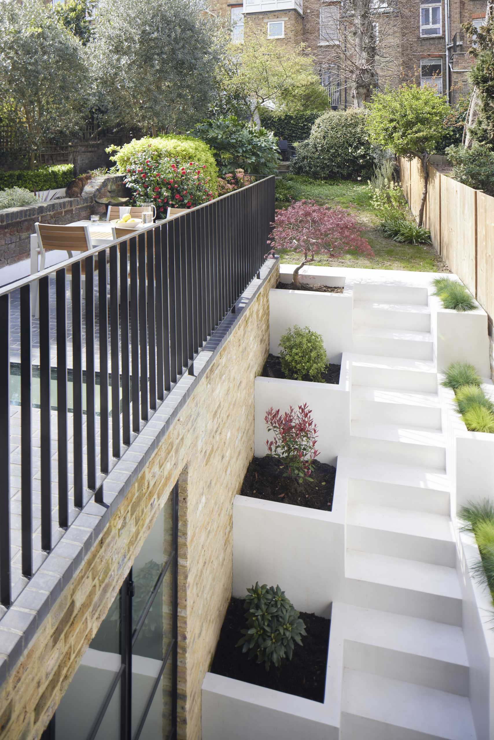 Outdoor stairs with built-in planters leads to a small patio and breakfast room.
