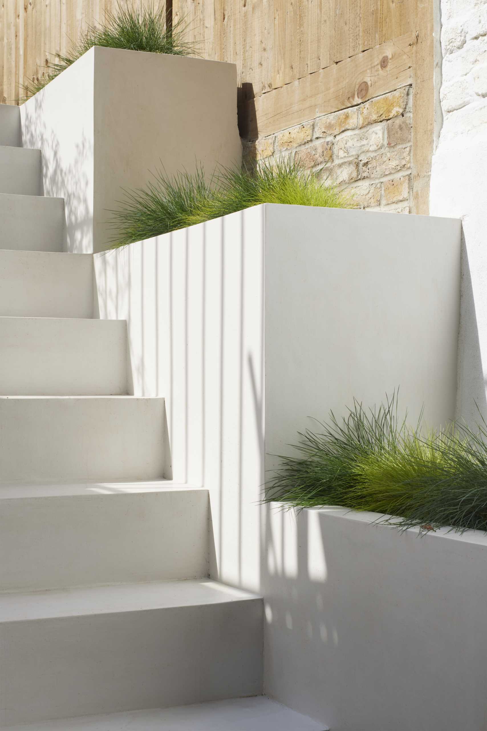 Outdoor stairs with built-in planters filled with grass.