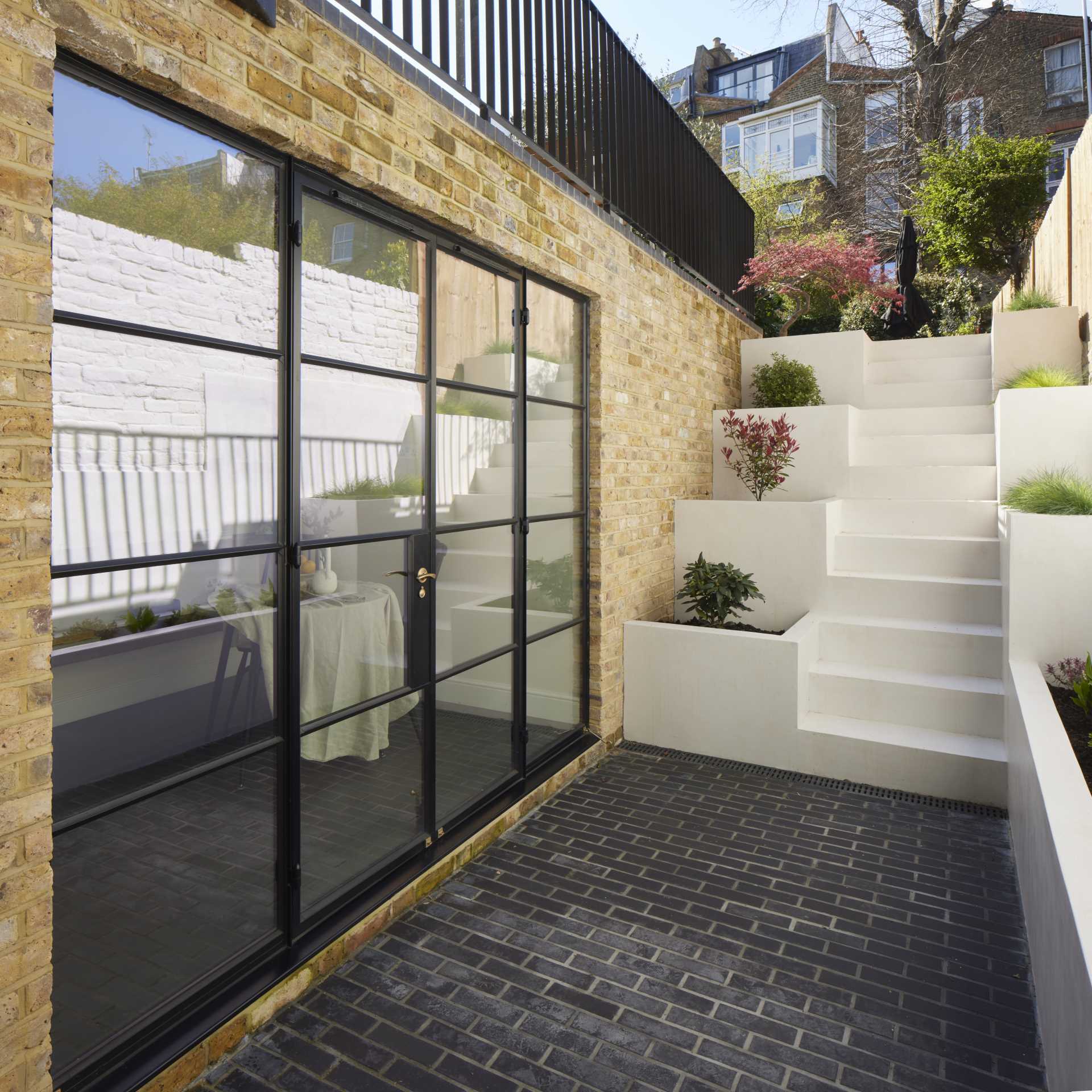 Outdoor stairs with built-in planters leads to a small patio and breakfast room.