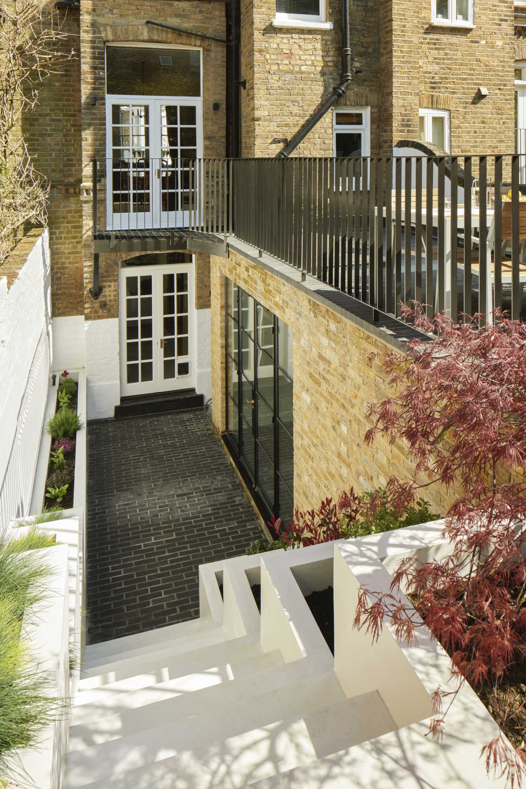 Outdoor stairs with built-in planters leads to a small patio and breakfast room.