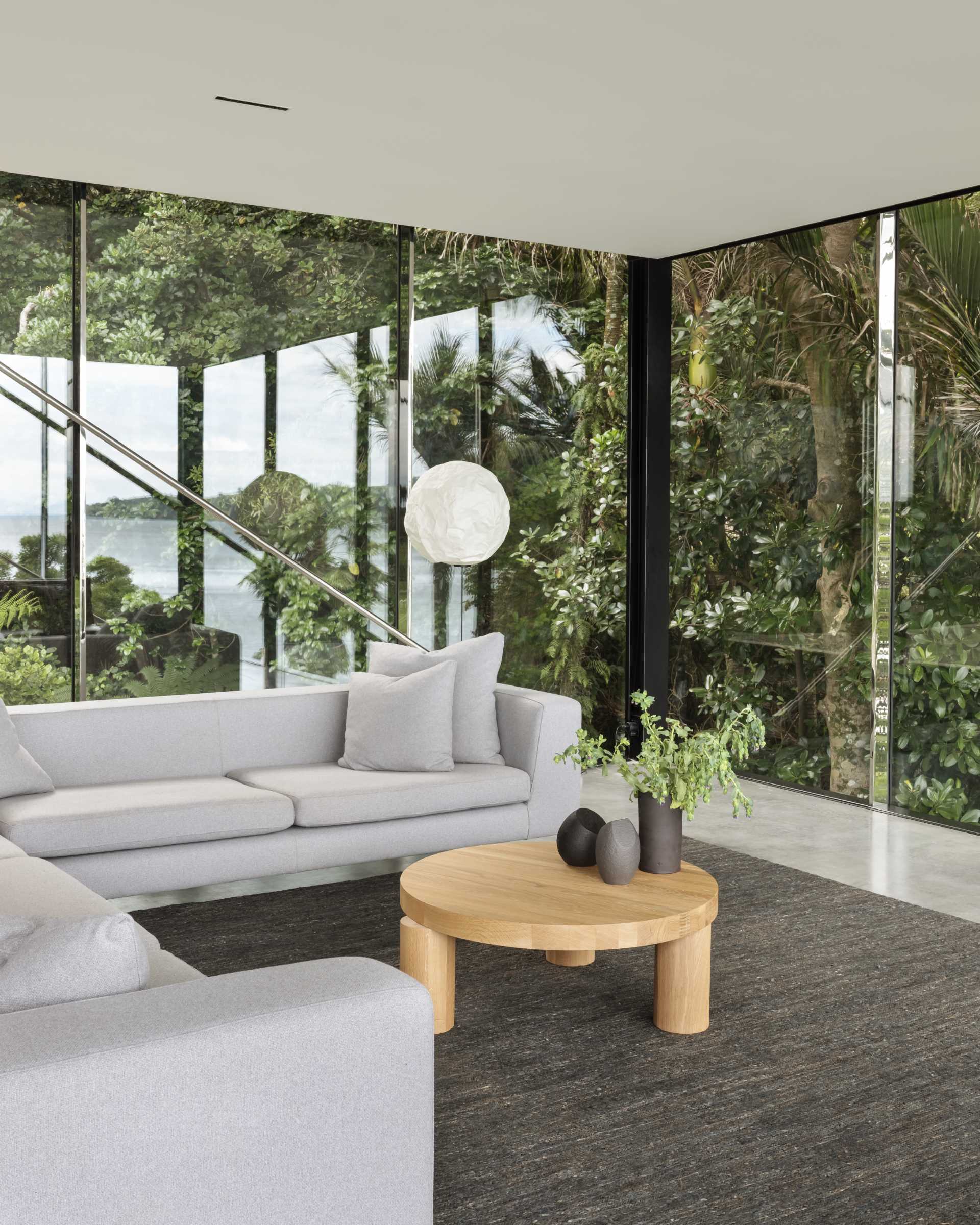 A modern home includes a living room with glass walls.
