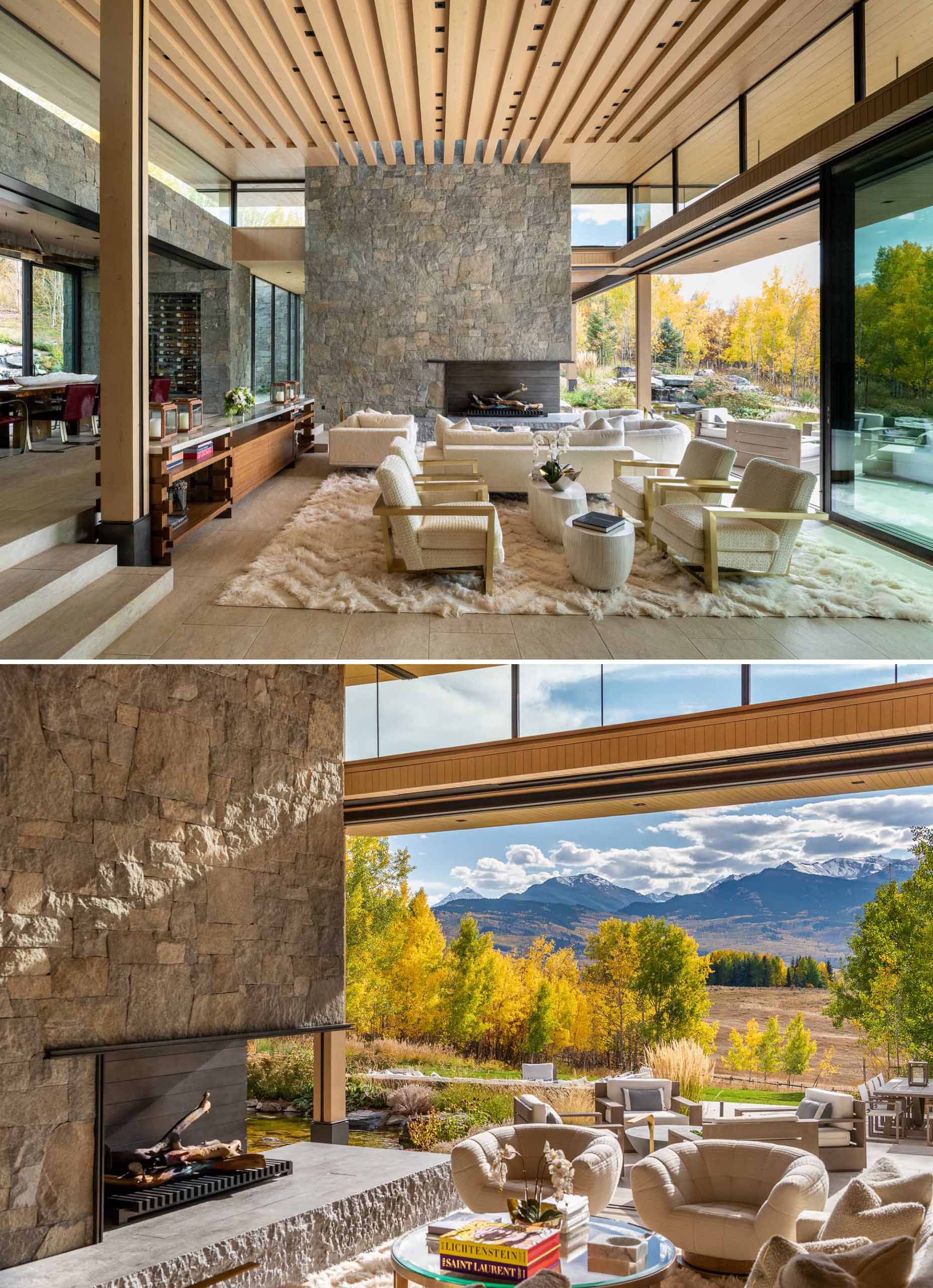 A modern living room with high wood ceilings and a steel-clad fireplace set within a massive stone element.