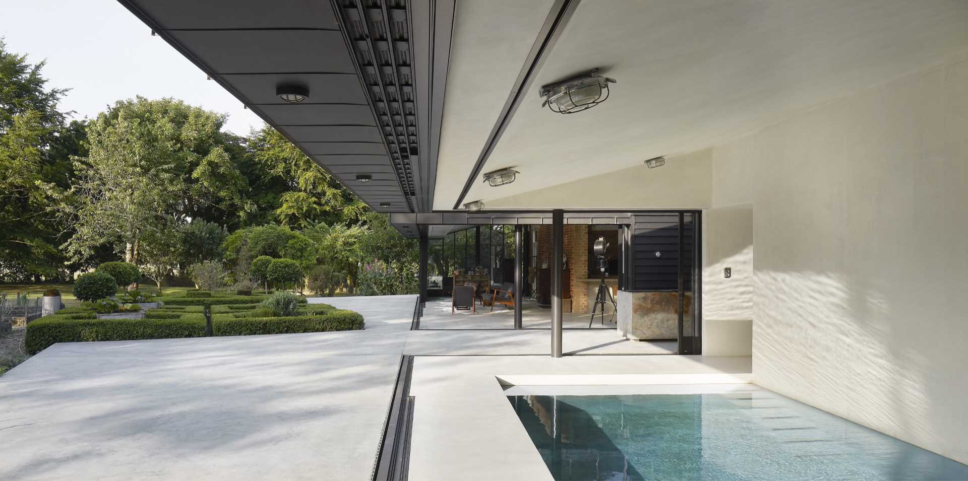 A modern pool house with an indoor pool and sliding glass walls.