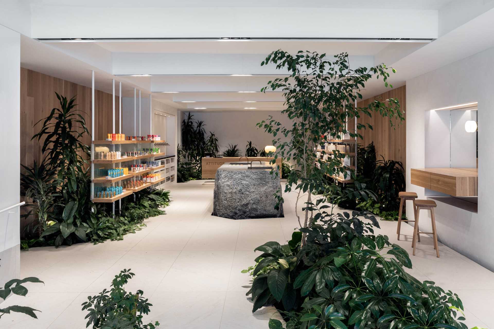 A modern retail store for a beauty brand includes built-in planters and stone accents throughout.