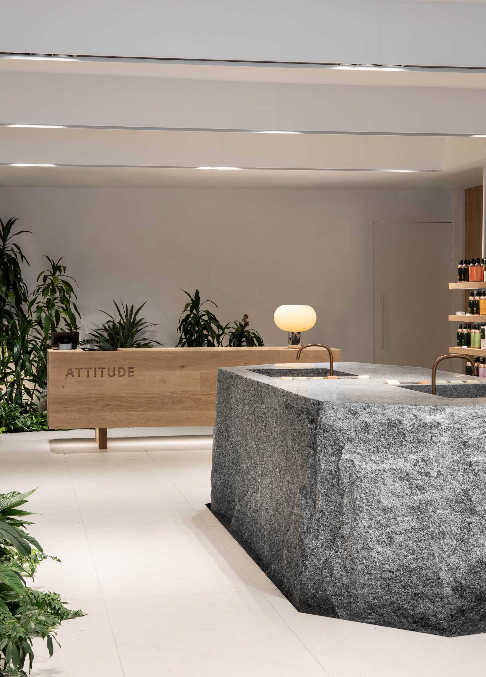 A modern retail store for a beauty brand includes built-in planters and stone accents throughout.