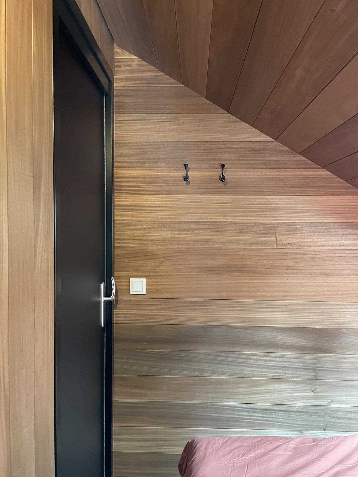 A modern bedroom with wood walls.