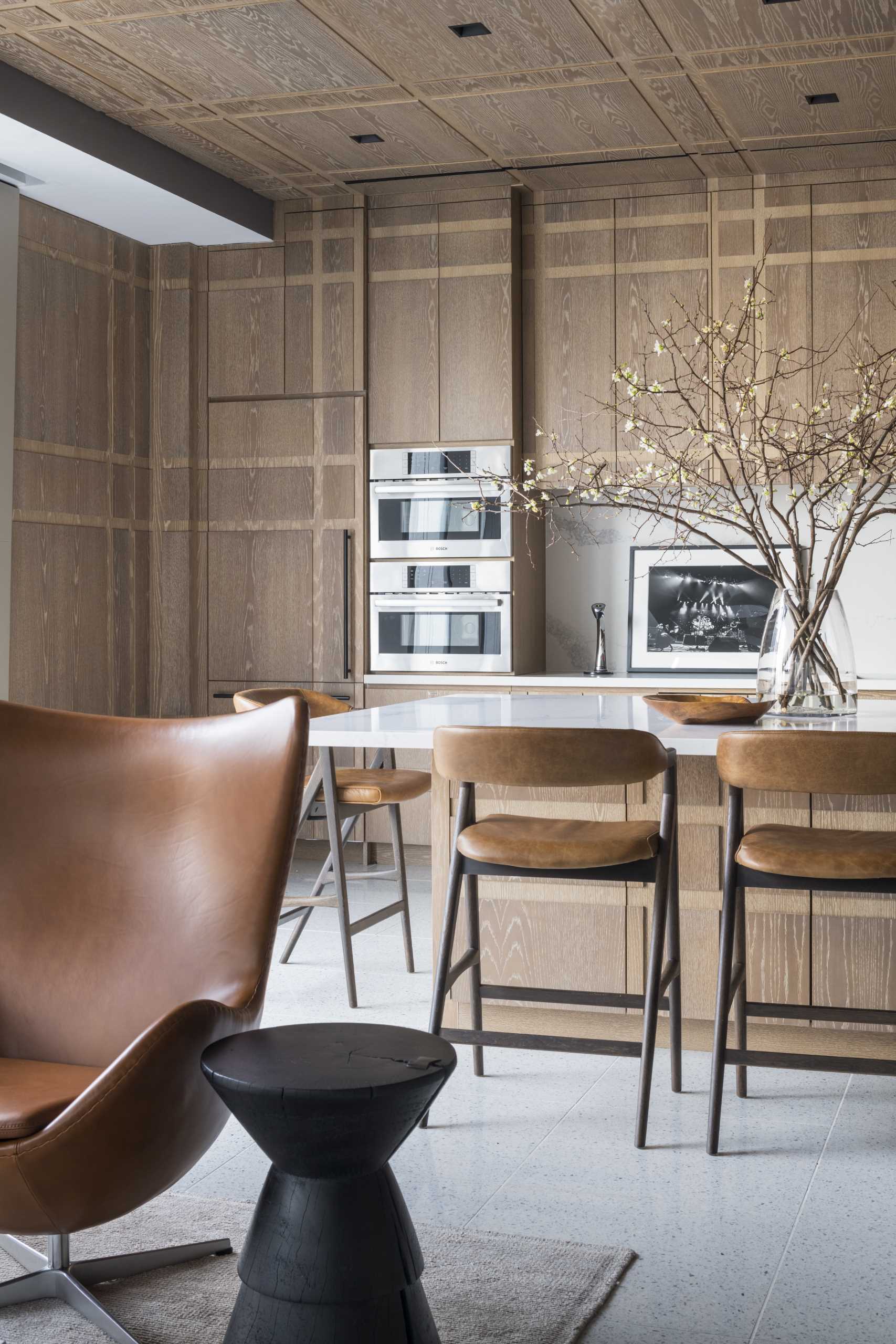 This plaid-inspired wood-clad kitchen was conceived as a pochéd white oak bookend, with wood covering all cabinets, appliances, doors, and the island.