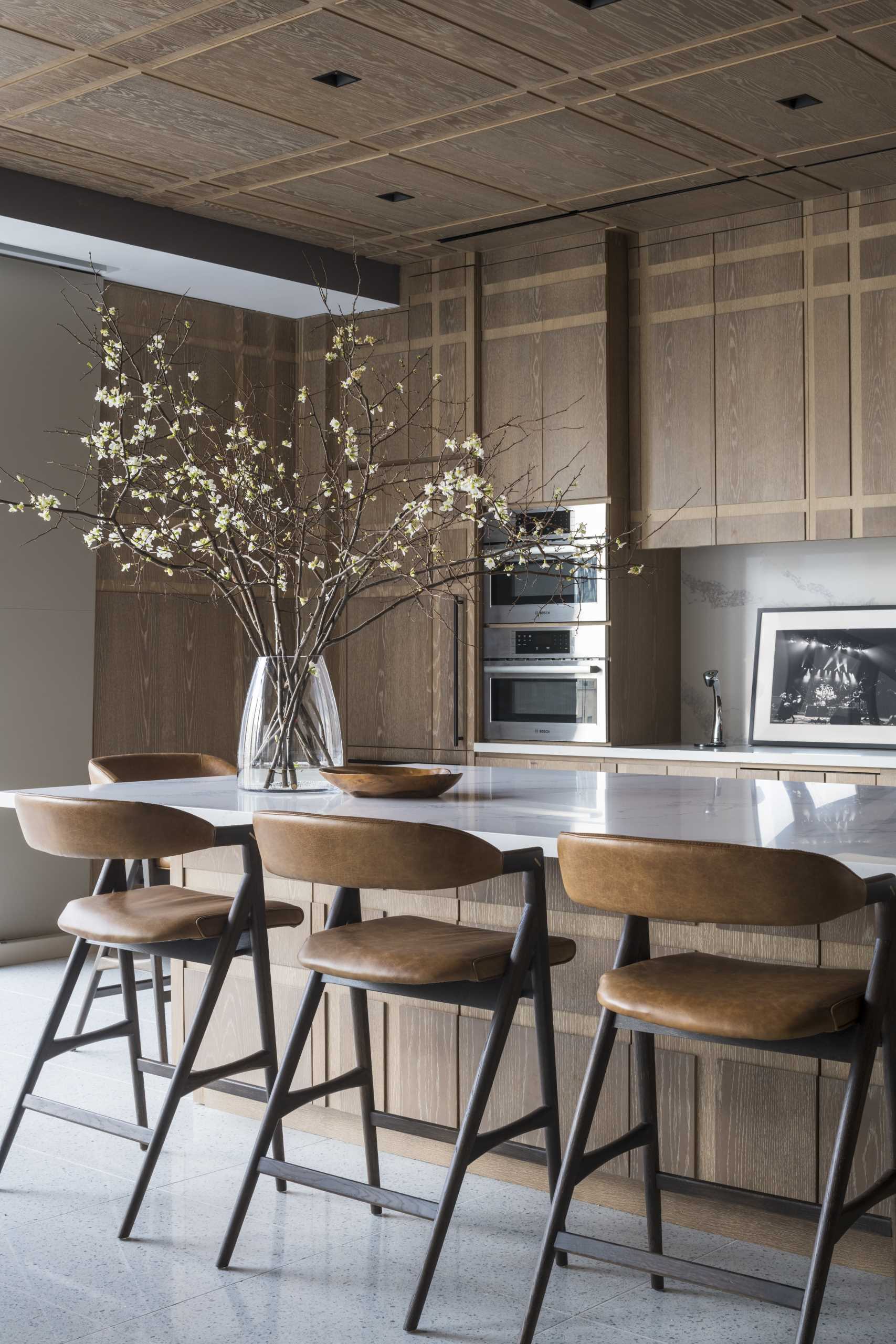 This plaid-inspired wood-clad kitchen was conceived as a pochéd white oak bookend, with wood covering all cabinets, appliances, doors, and the island.