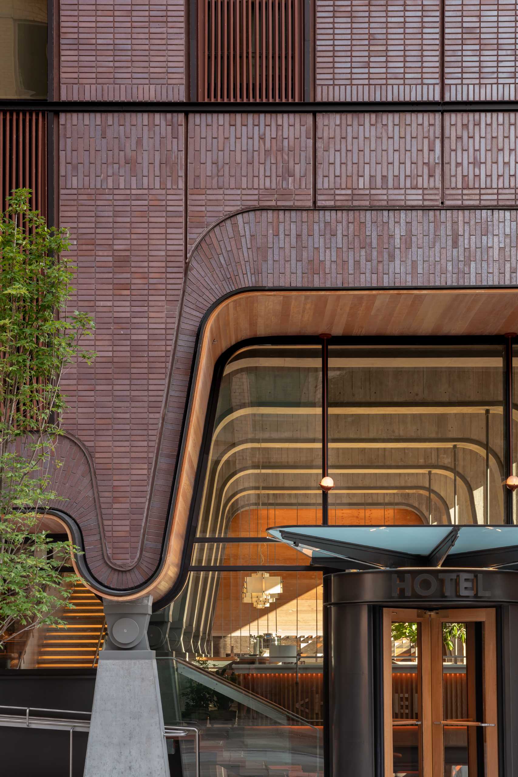 The Ace Hotel in Toronto has patterned red brick exterior with a uniquely shaped opening.