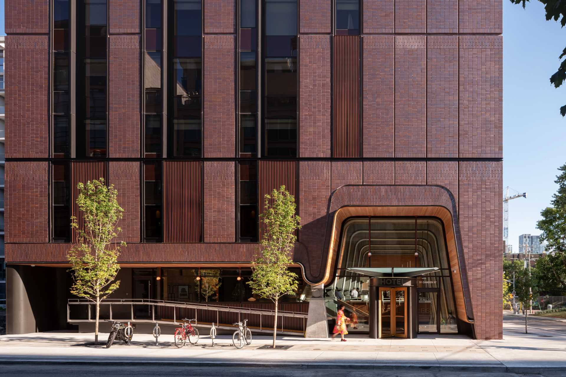 The Ace Hotel in Toronto has patterned red brick exterior with a uniquely shaped opening.