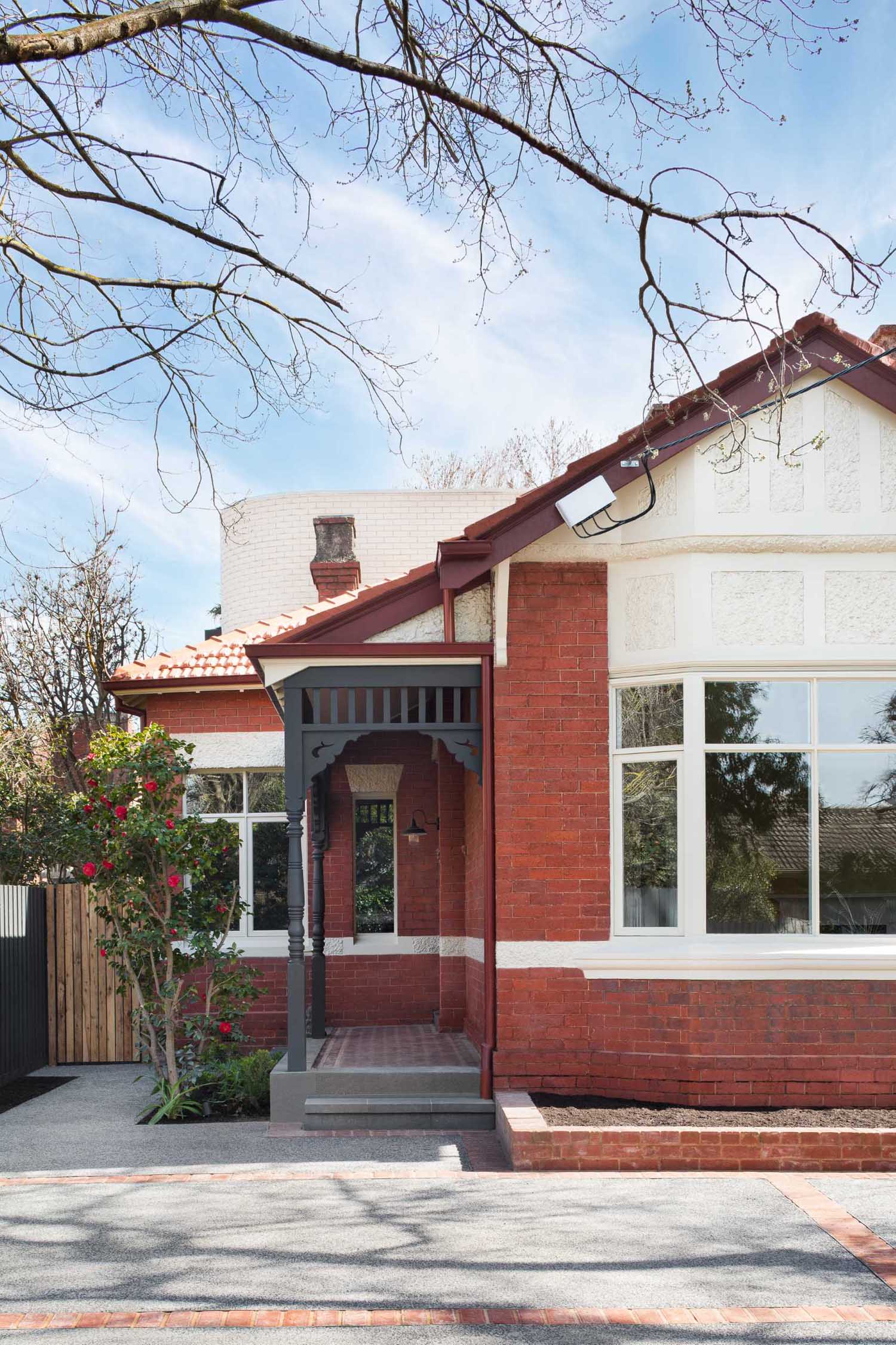 An Australia red brick home with a modern light brick rear addition.