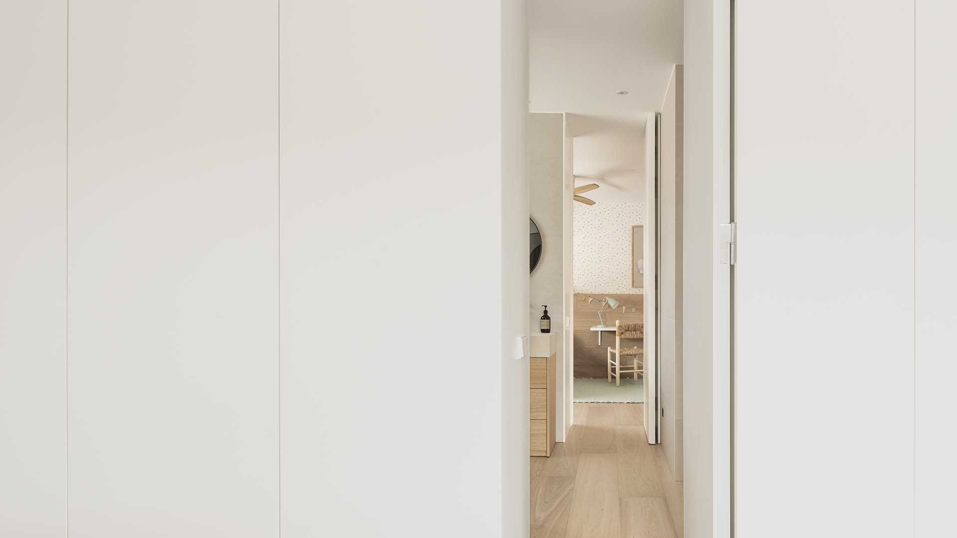 A modern jack-and-jill bathroom with separate vanities and a walk-in shower.