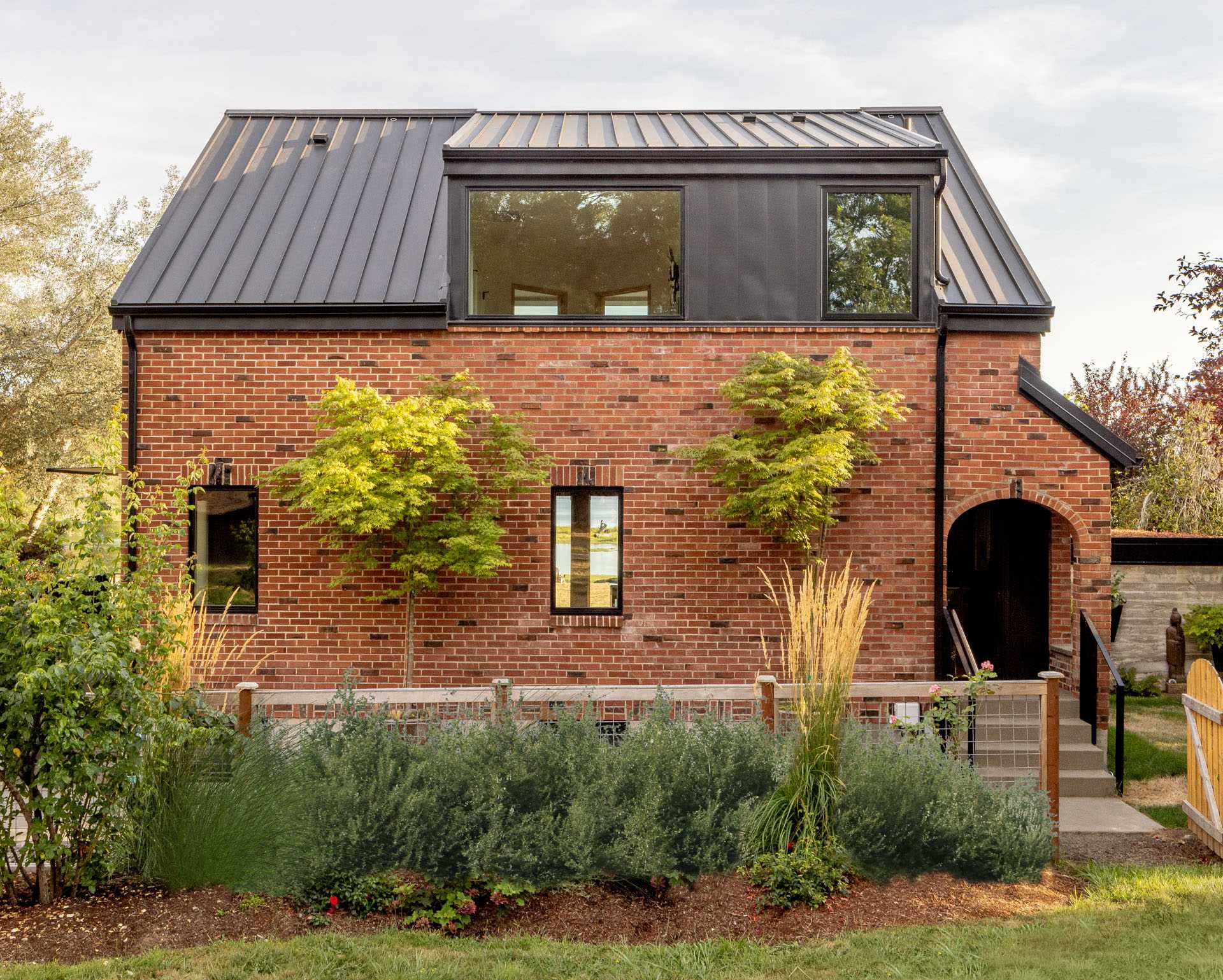 An updated brick home with new windows and a side entrance.