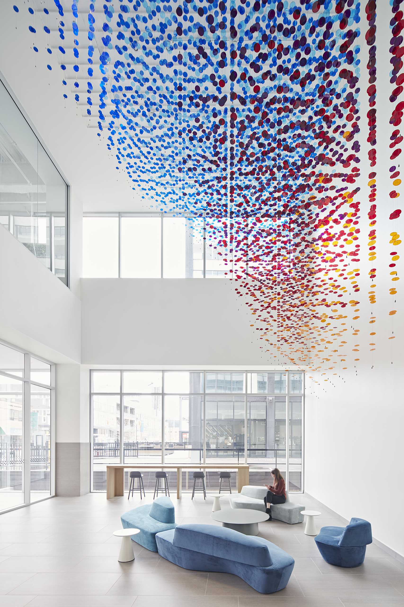 A custom-installation in a lobby atrium is made from 8,000 colorful discs suspended from 650 wire cables.