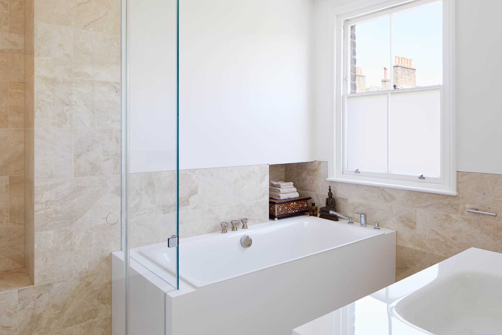 In this bathroom, light-colored tiles are paired with white walls for a contemporary look.