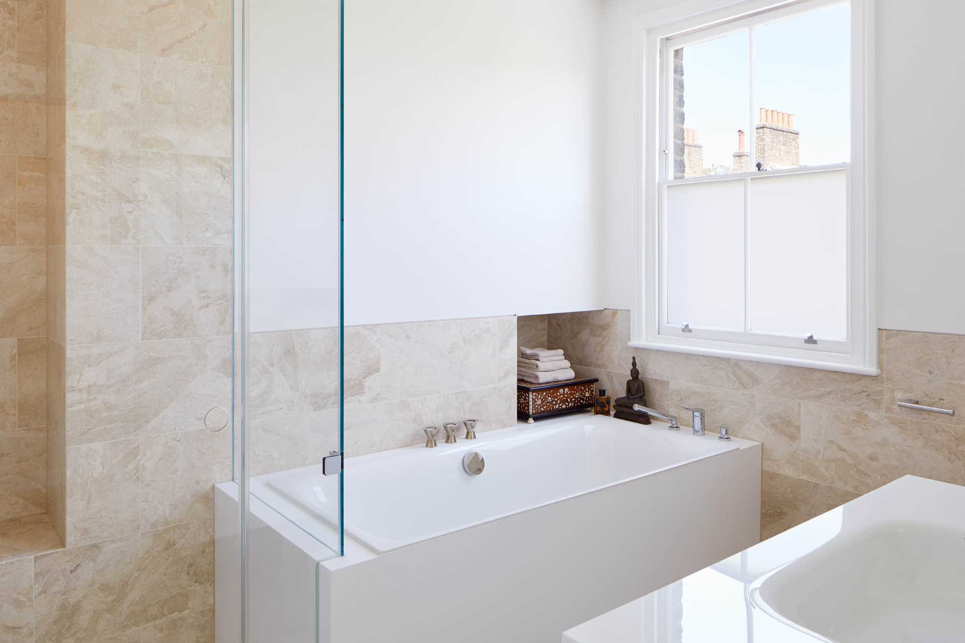 In this bathroom, light-colored tiles are paired with white walls for a contemporary look.