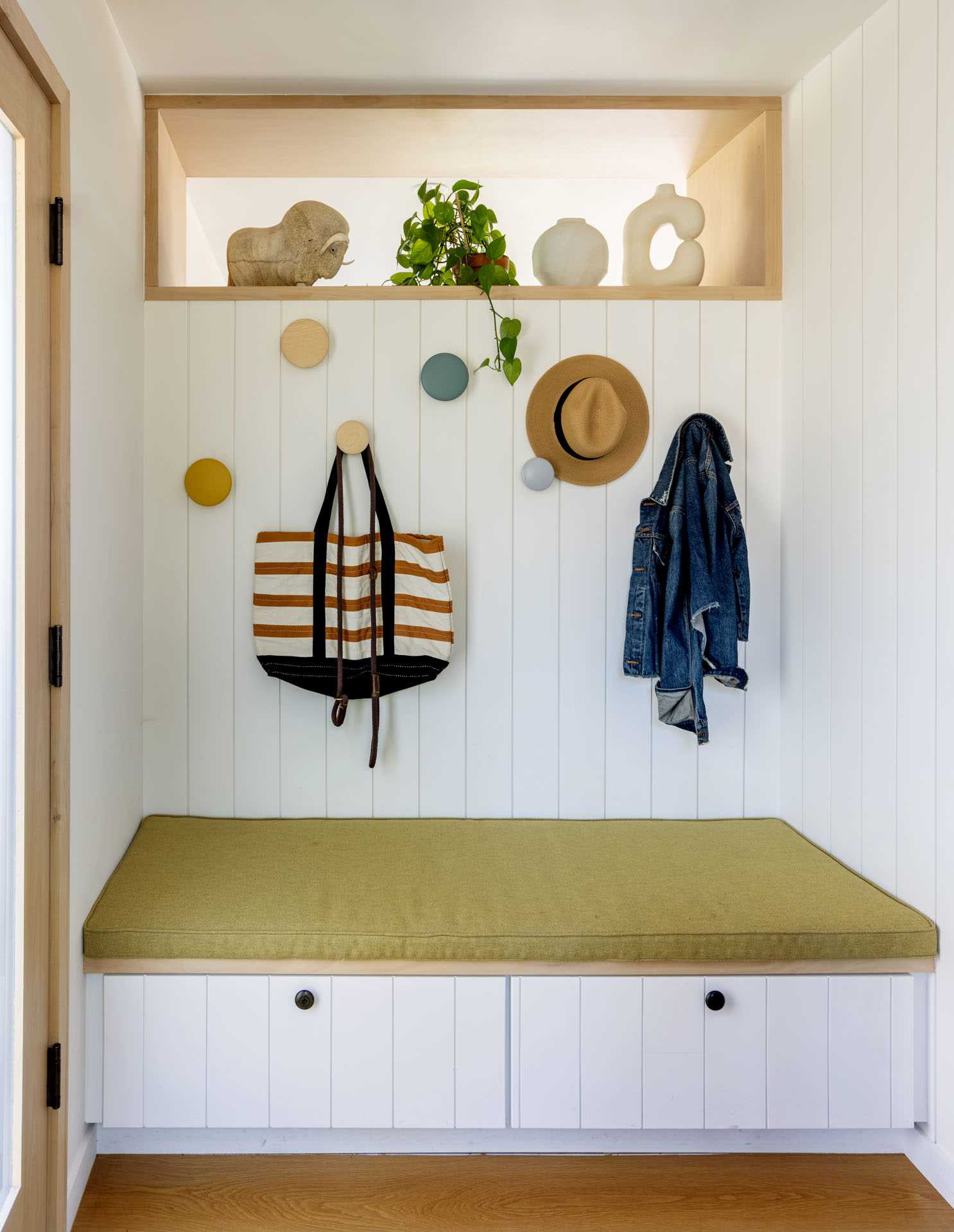 An entryway with a built-in bench and wall hooks.