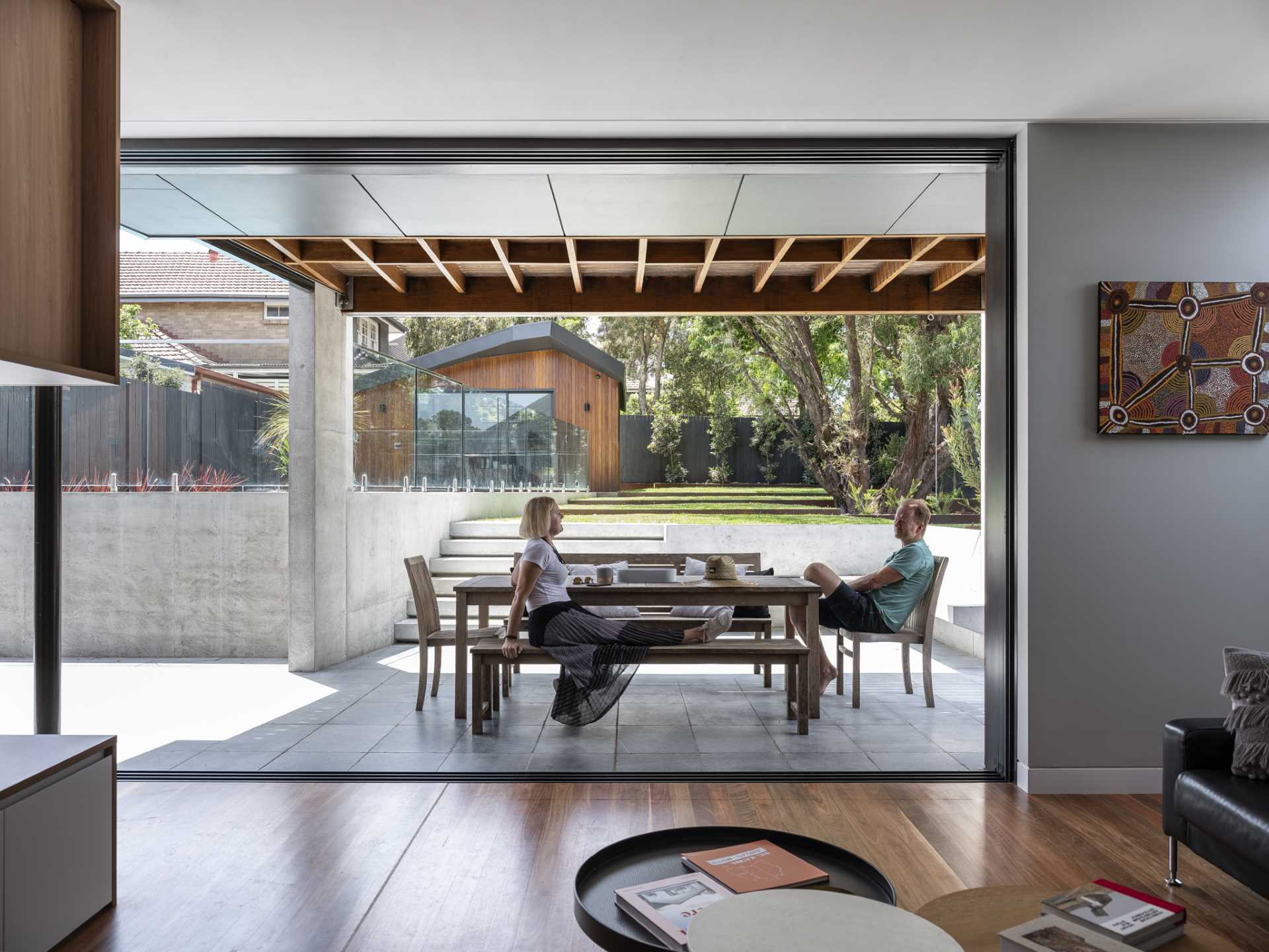 The outdoor spaces connect to the interior spaces of this modern home with a large sliding door. 