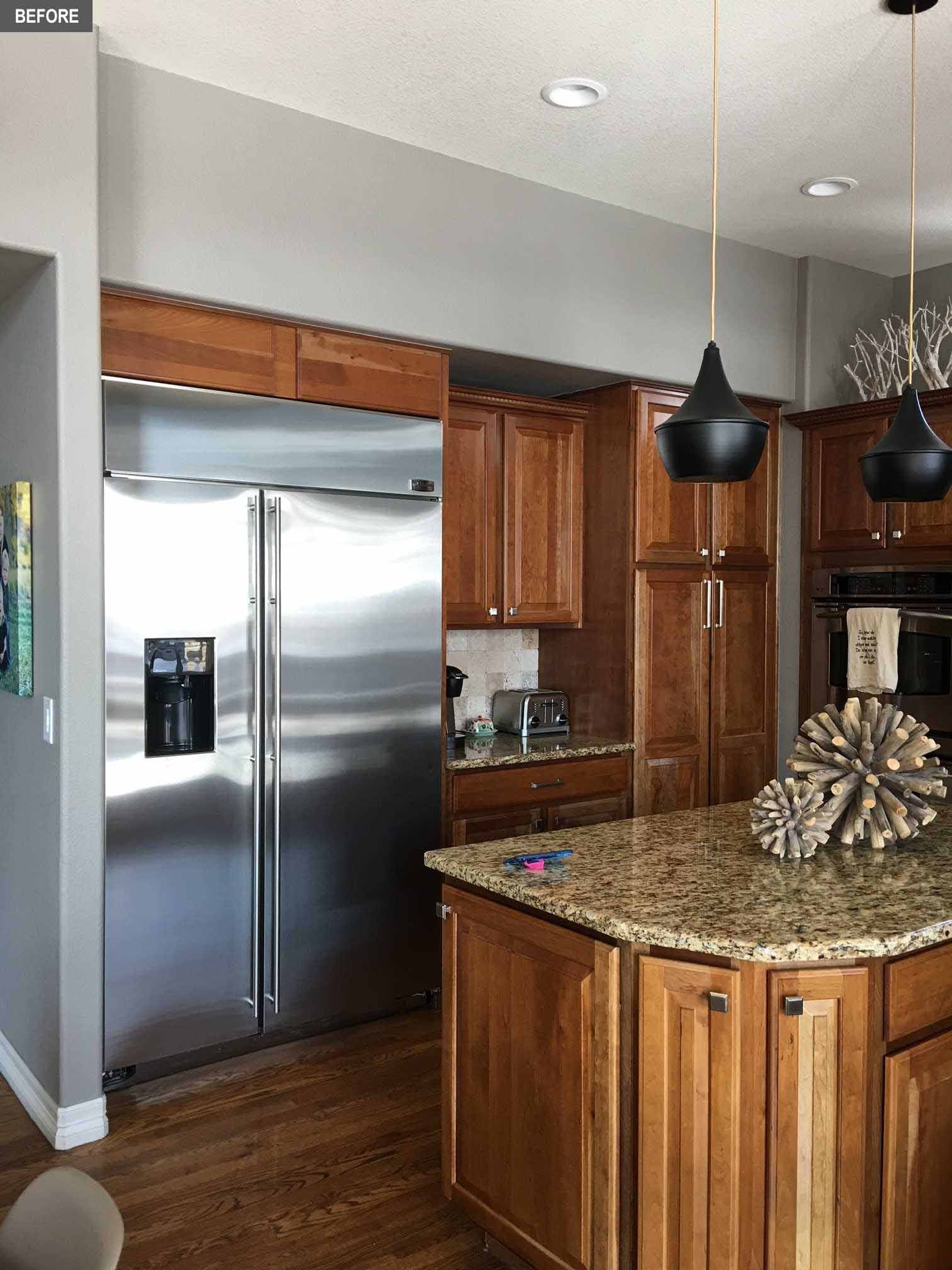 BEFORE - A dated kitchen includes builders-grade kitchen with wood cabinets that made the space quite dark.