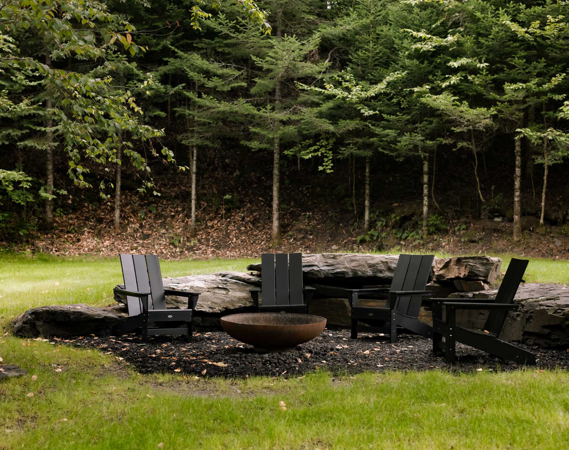 A landscaped fire pit with a partial rock wall.