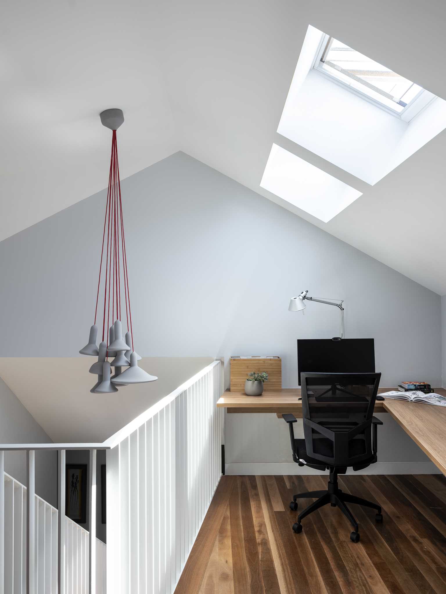 A small home office is located at the top of the stairs leading to the upper level of this home.