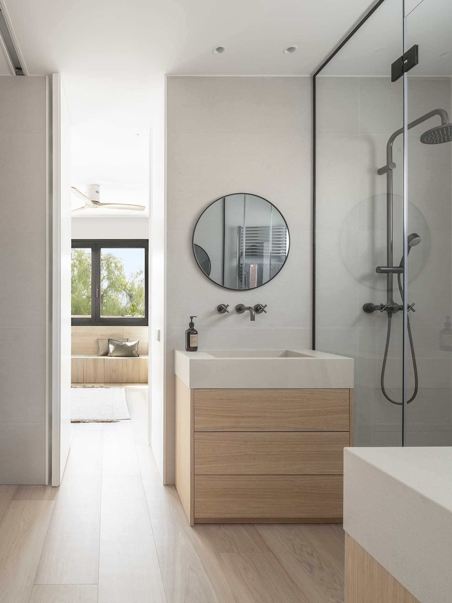 A modern jack-and-jill bathroom with separate vanities and a walk-in shower.