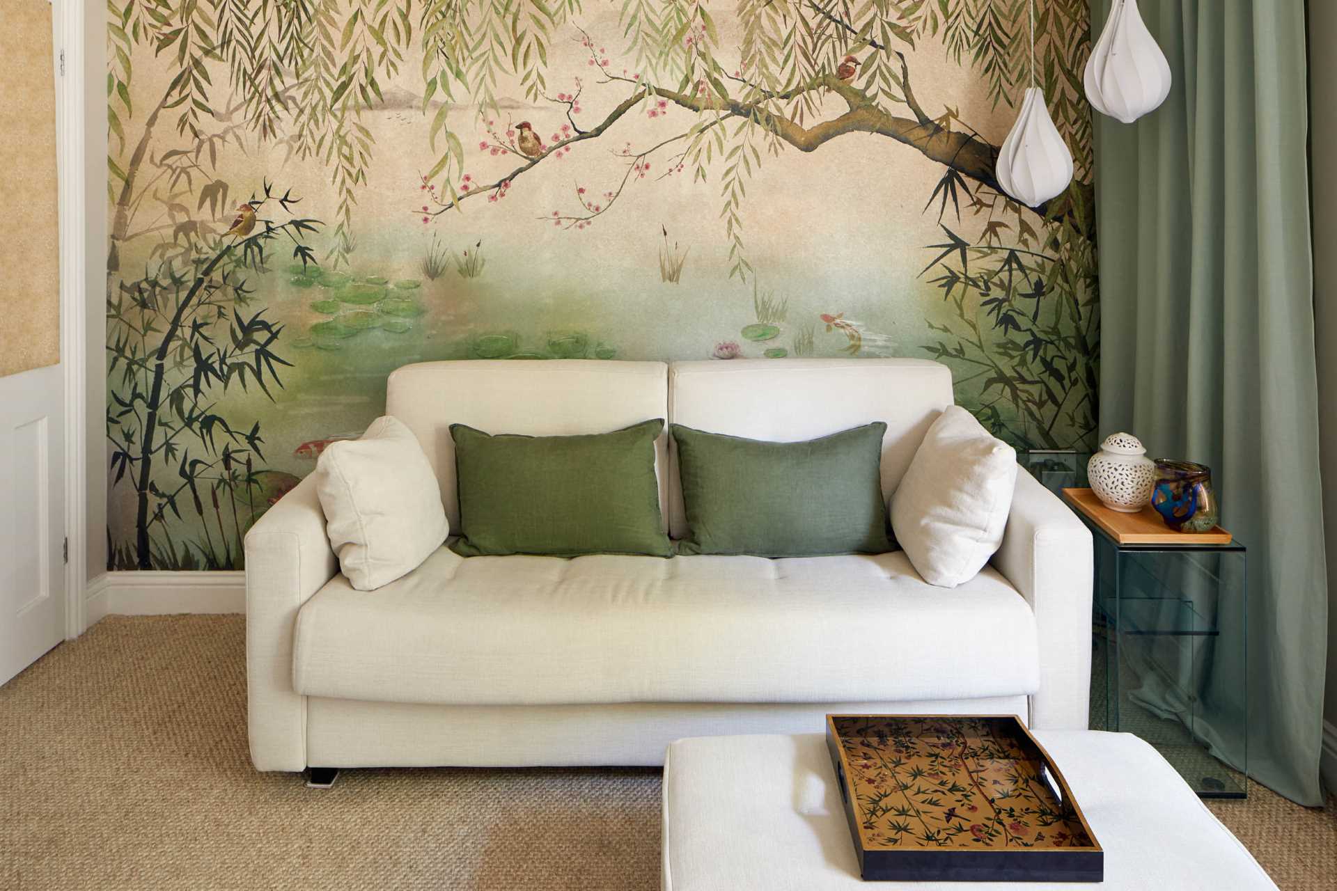A living room that has a large nature mural that covers the wall.