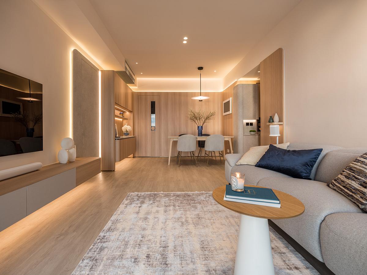 A modern open plan dining area and living room with hidden LED lighting.