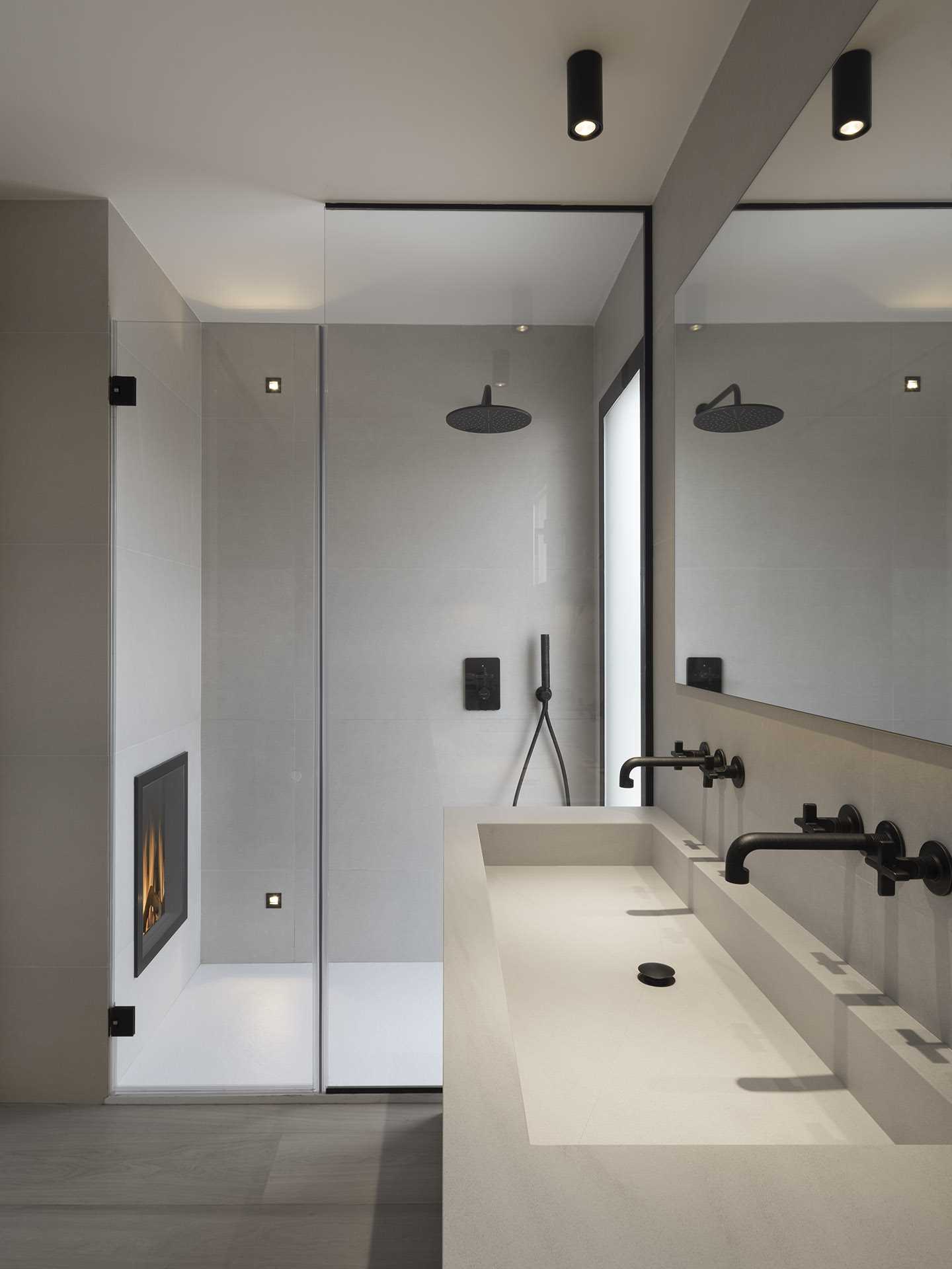 A modern bathroom with a fireplace in the shower.