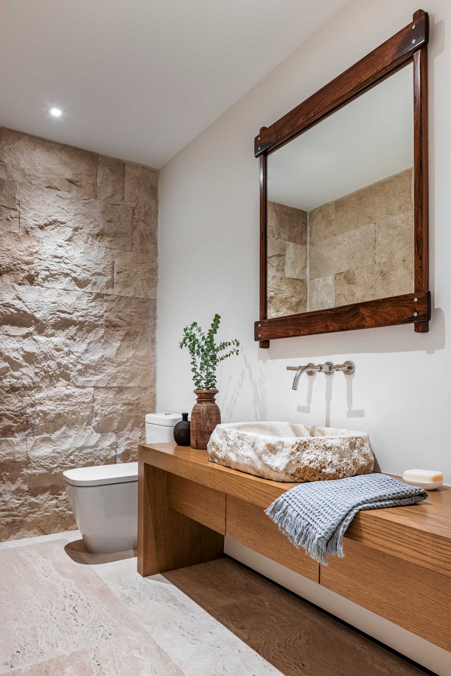 Trong phòng tắm chính hiện đại này, tường và bồn tùy chỉnh được làm từ đá Jerusalem giống như bên ngoài.