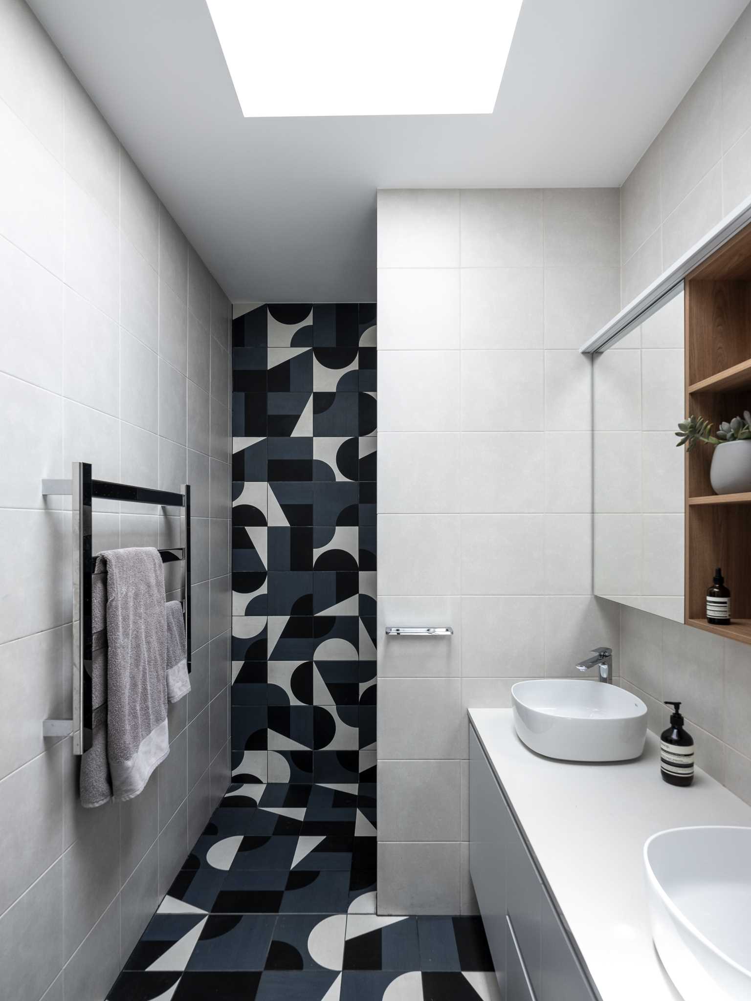 In this bathroom, the graphic tiles on the wall and floor add a playful touch.