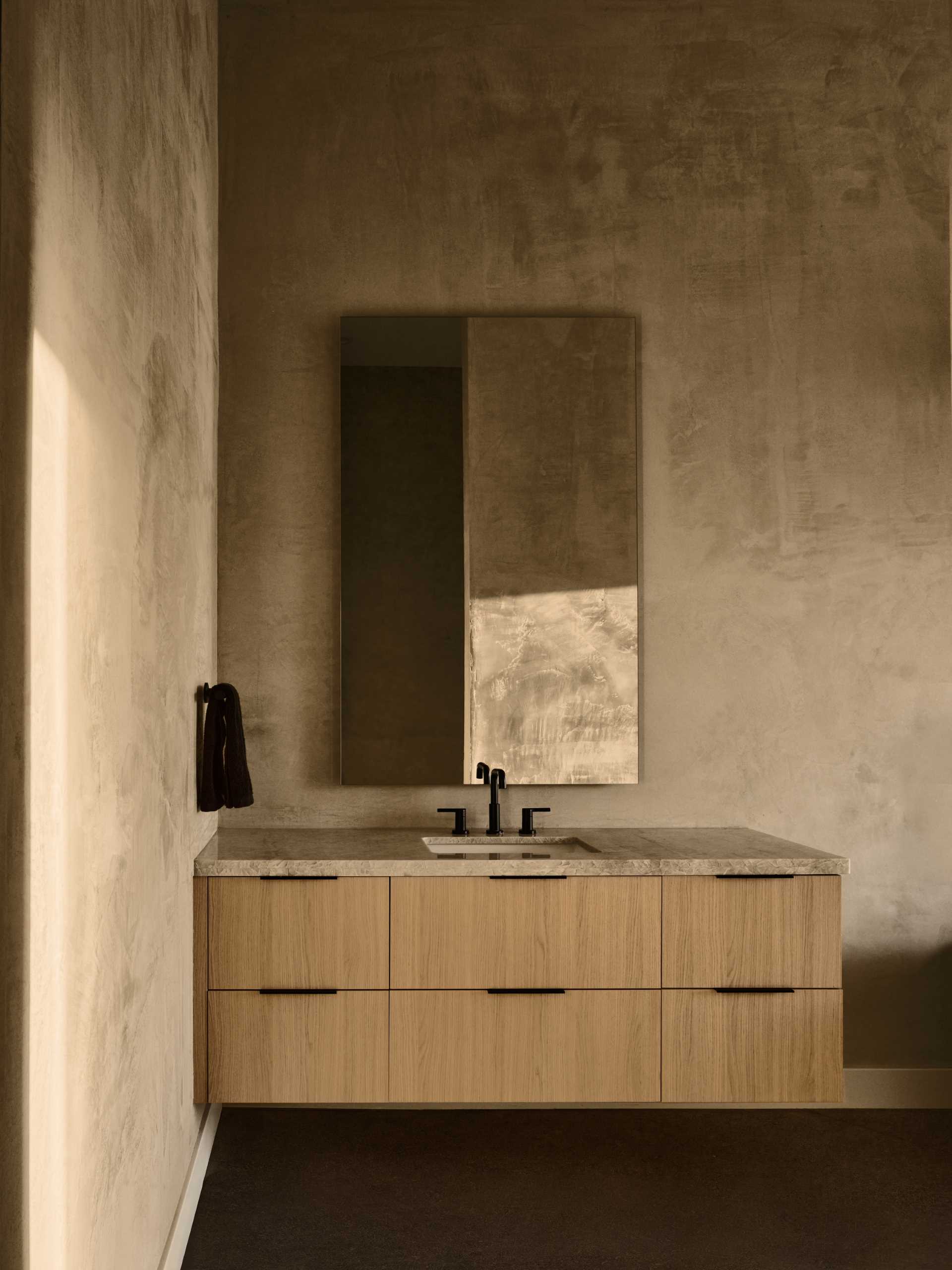 A modern and earth bathroom with a wood vanity.