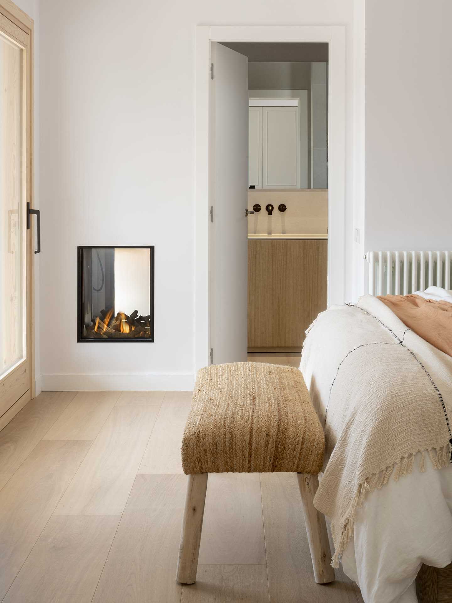 This modern bedroom has a double-sided fireplace that can be enjoyed from the bedroom and from within the shower in the en-suite bathroom.