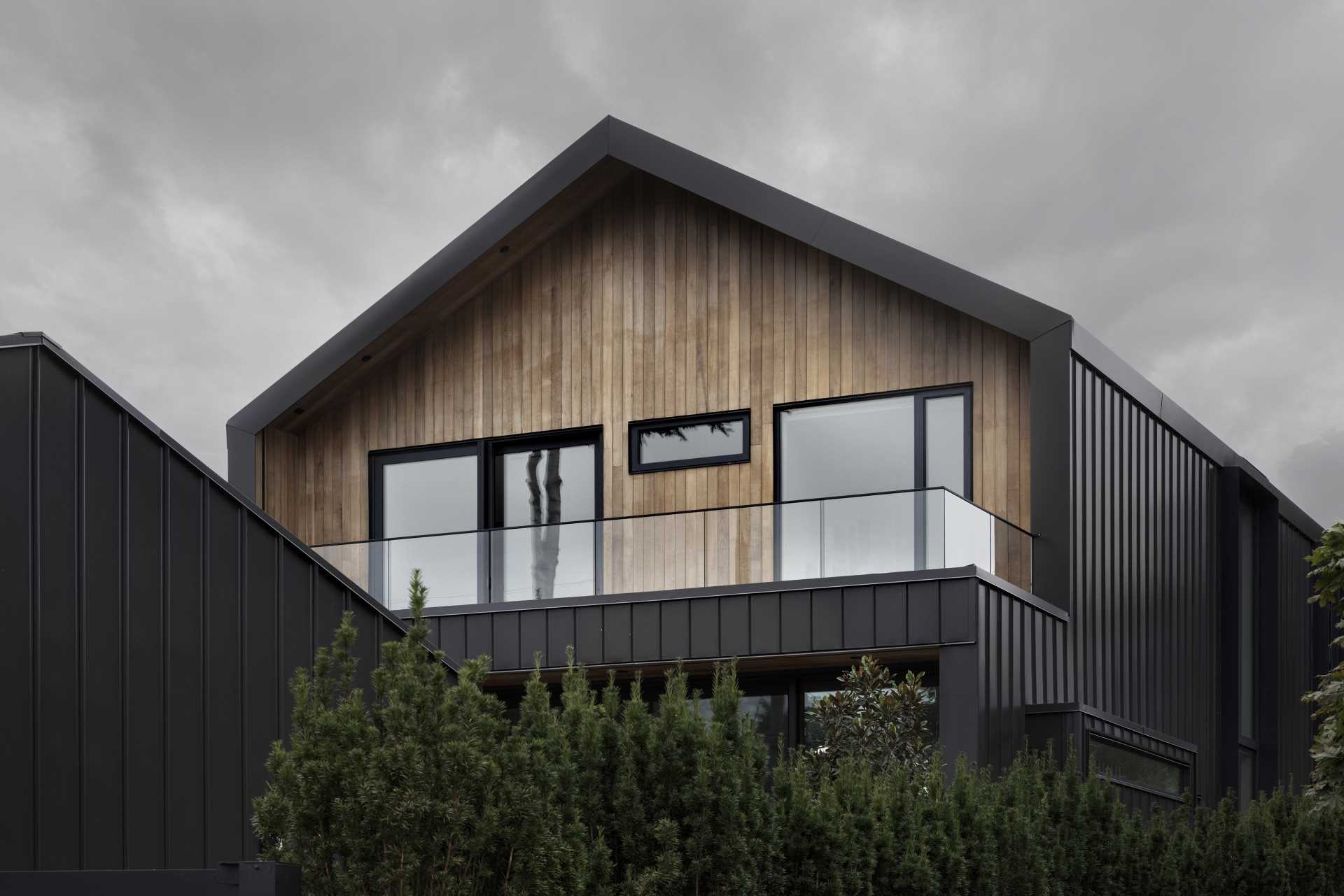 The front and rear facades are clad with naturally stained cedar siding to exhibit a tone similar to that of the forests near the site.